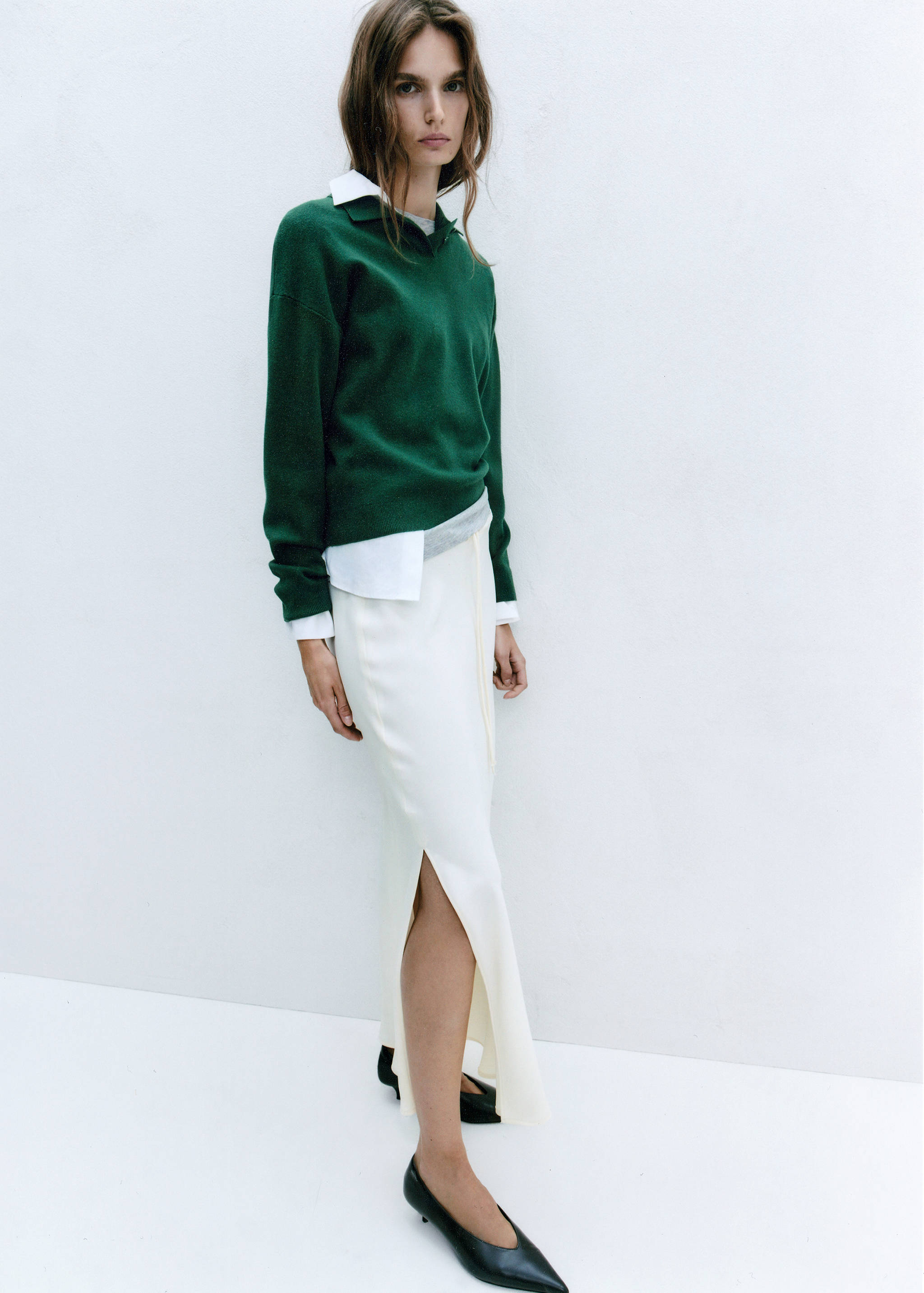 Dark green knitted jersey with a collar, layered over a white shirt.