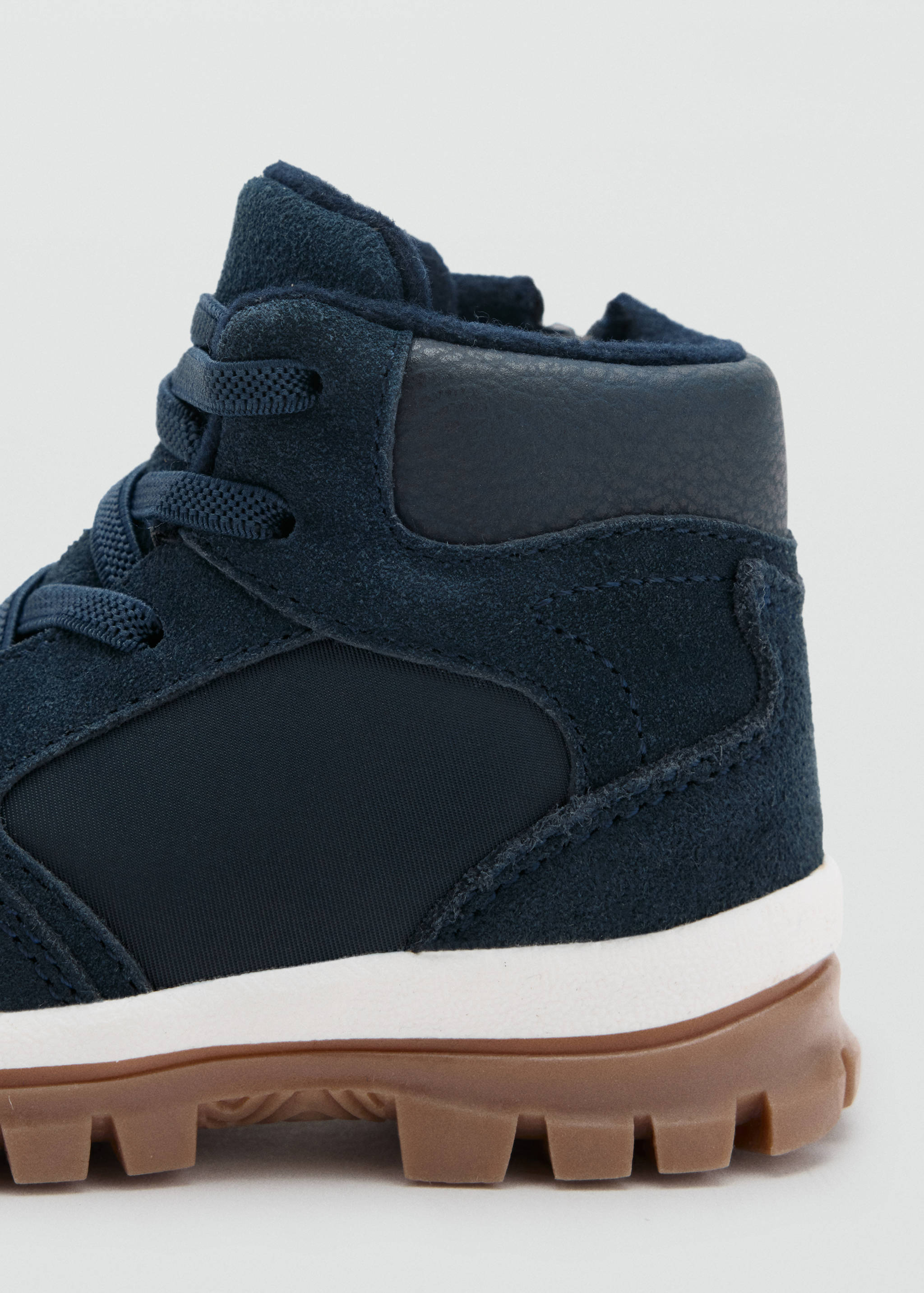 Navy blue kids boot close-up showing suede upper and rugged sole.