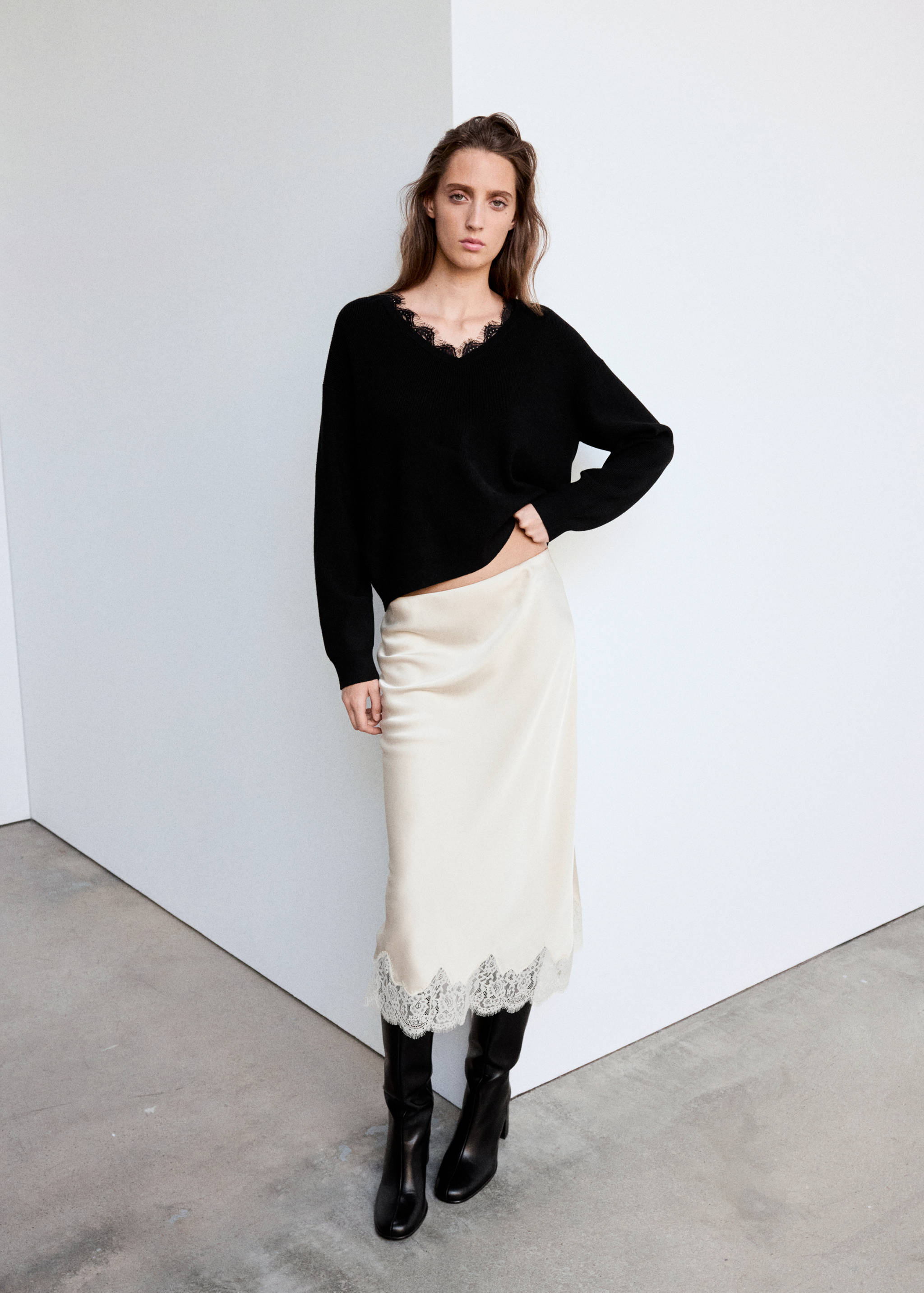 Black V-neck jersey with lace trim, worn with a satin skirt.