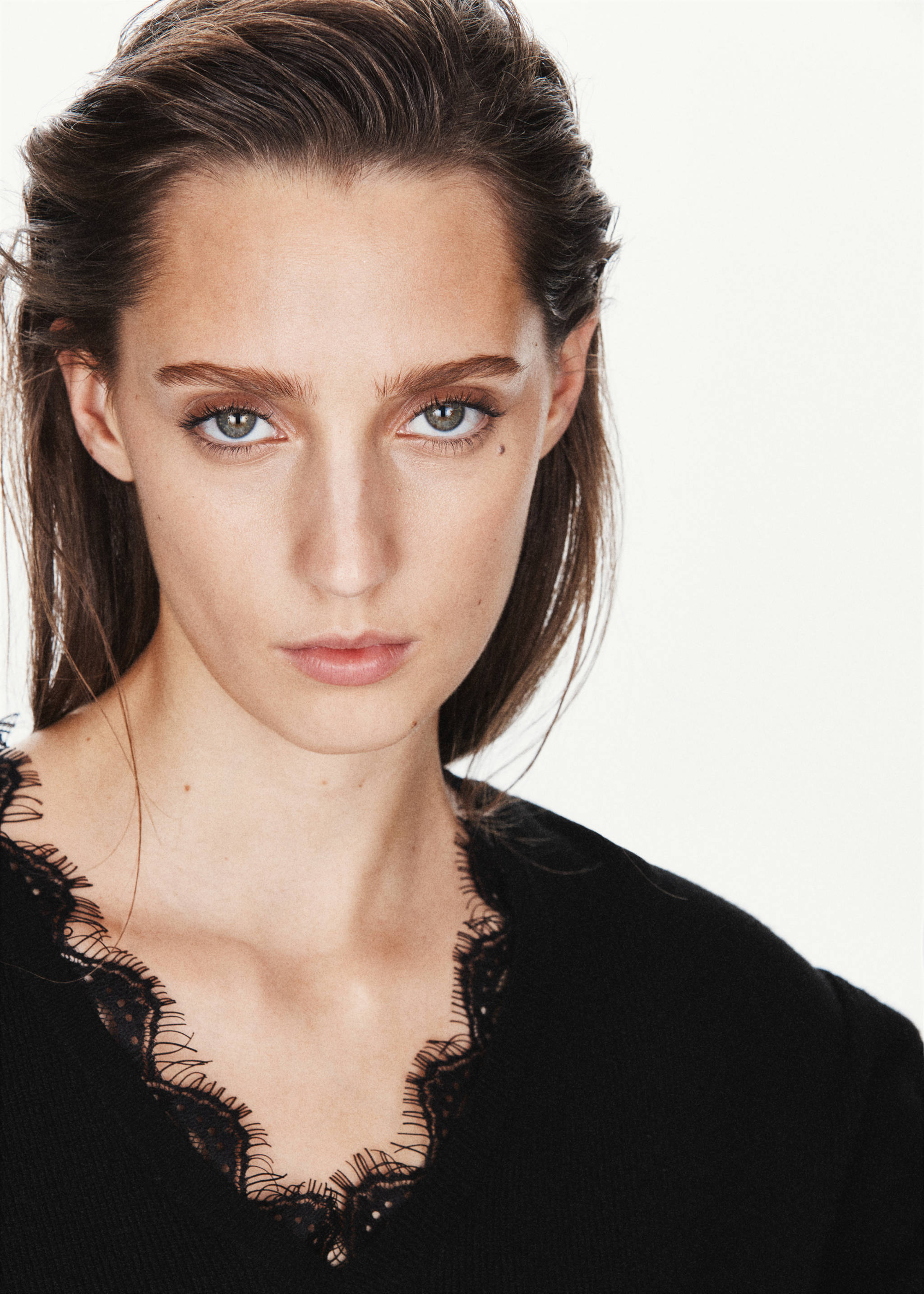 Close-up of a black V-neck jersey with lace trim.