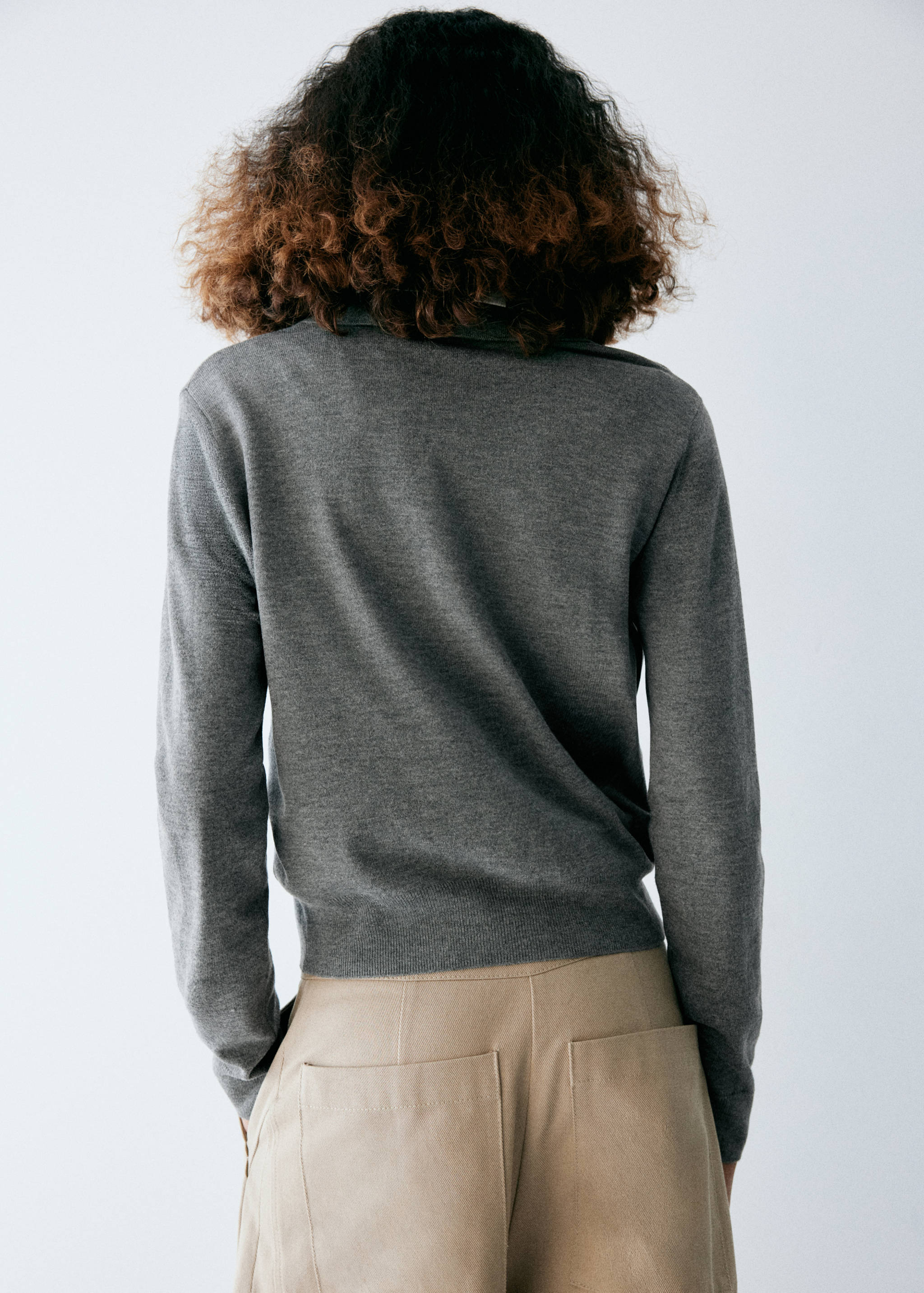 Grey knit jersey sweater from the back, showing long sleeves and collar.