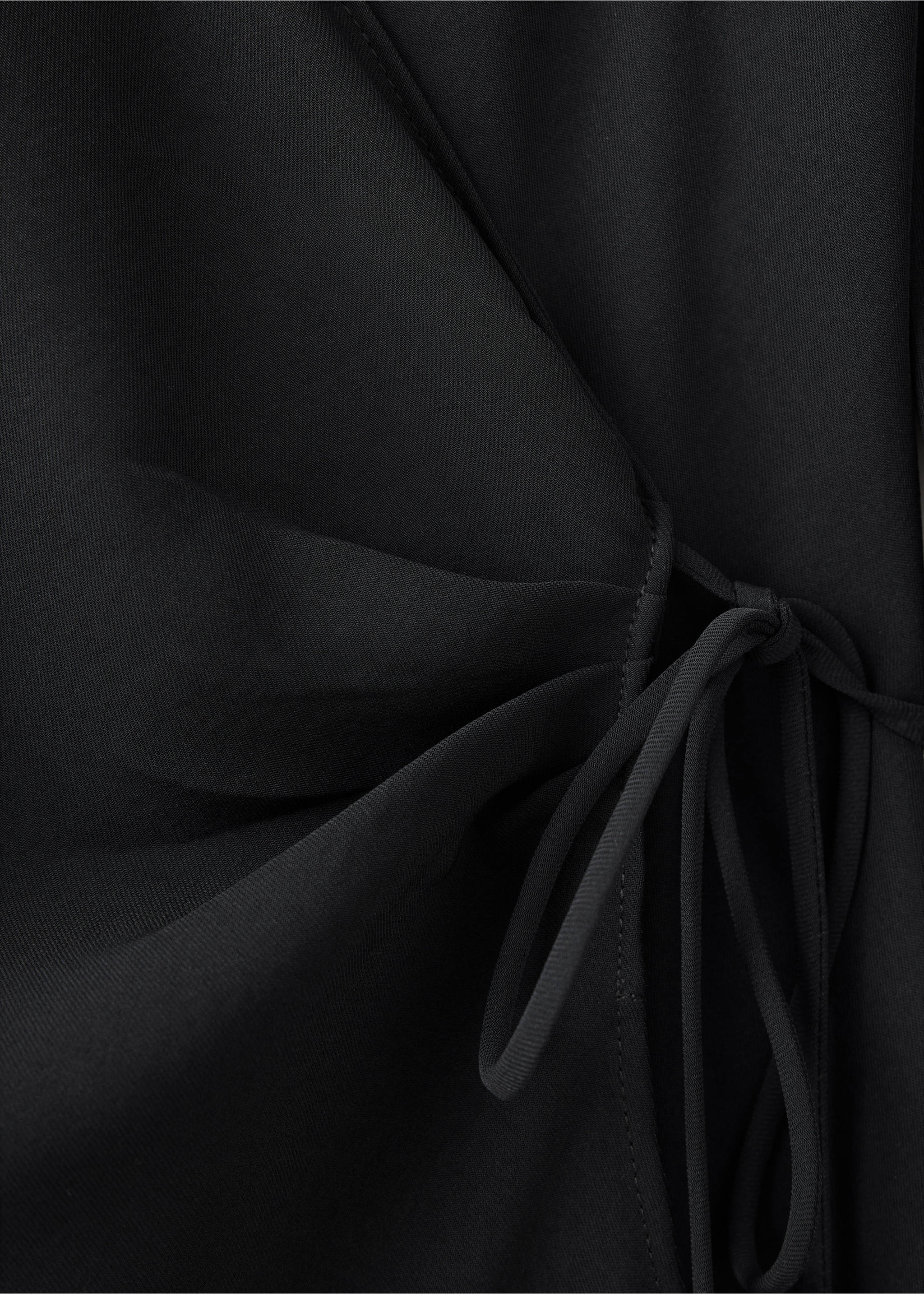 Primer plano de un vestido cruzado negro que muestra el cierre de lazada lateral., Negro. Ref: 37017795-00.