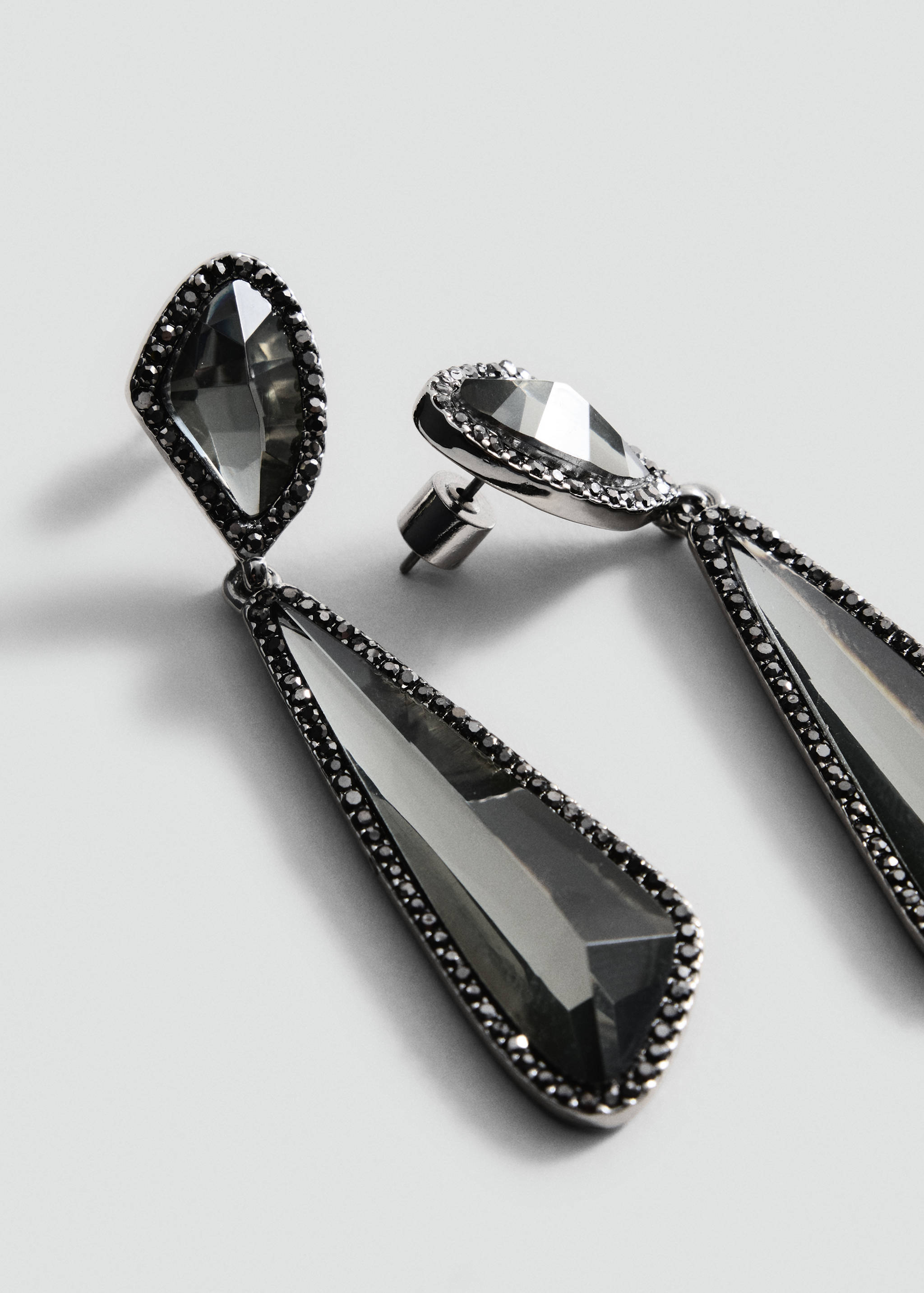 Crystal drop earrings in dark metallic settings with encrusted small stones.