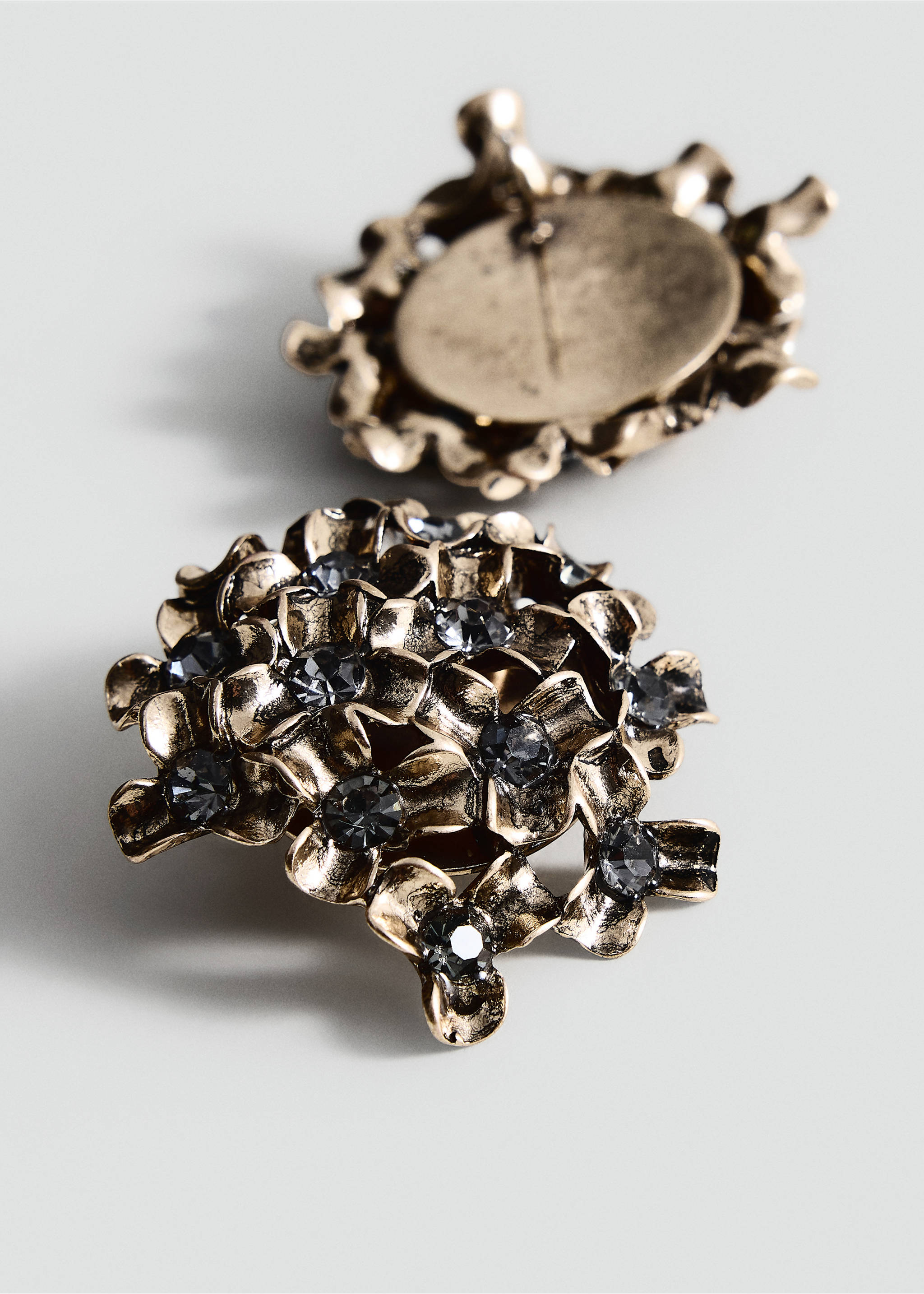 Close-up of golden floral cluster earrings with dark grey crystals., Grey. Ref: 37017803-00.