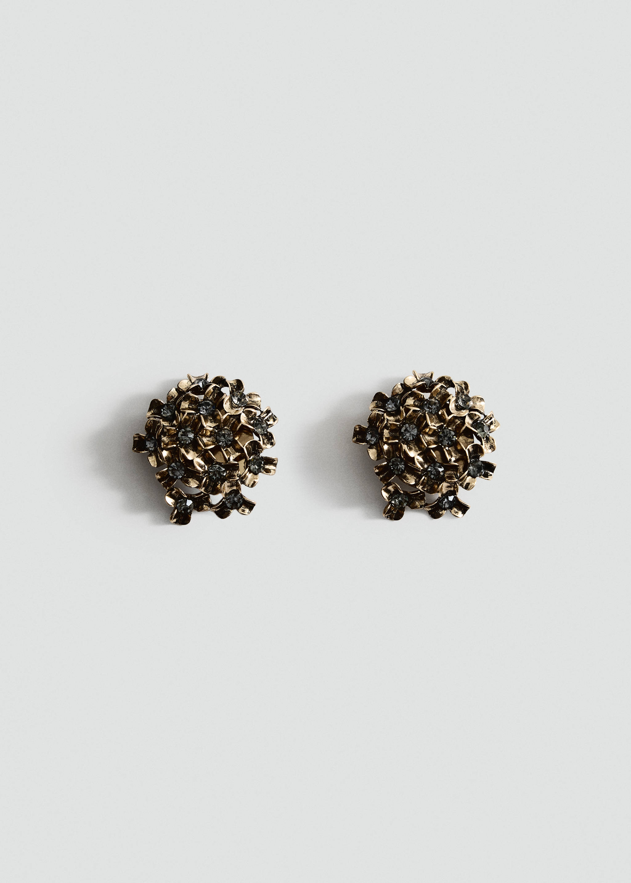 Gold-toned metallic earrings with clustered floral elements and dark crystals.