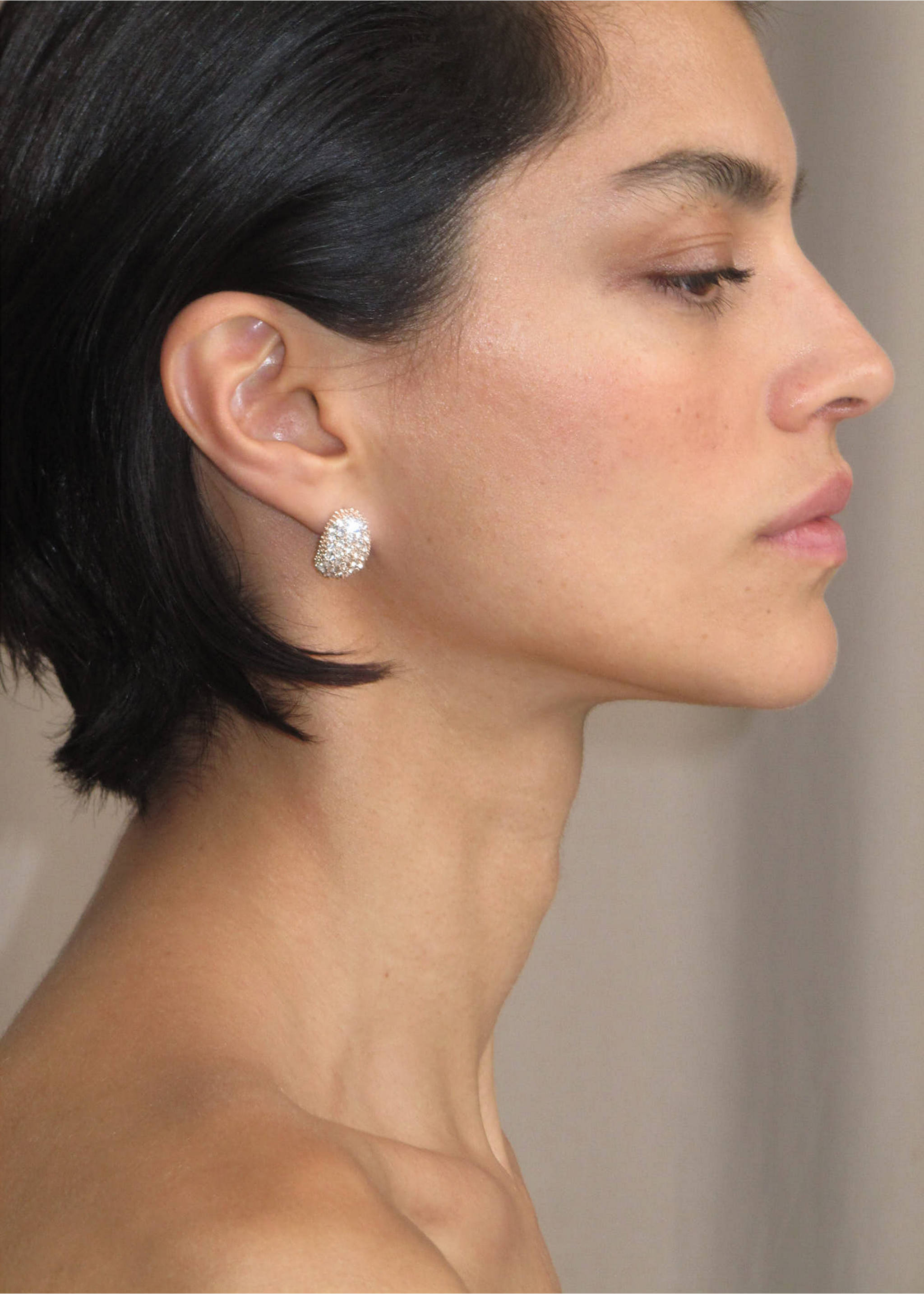 Sparkling crystal pavé dome hoop earrings on a model's ear., Gold. Ref: 37017805-00.