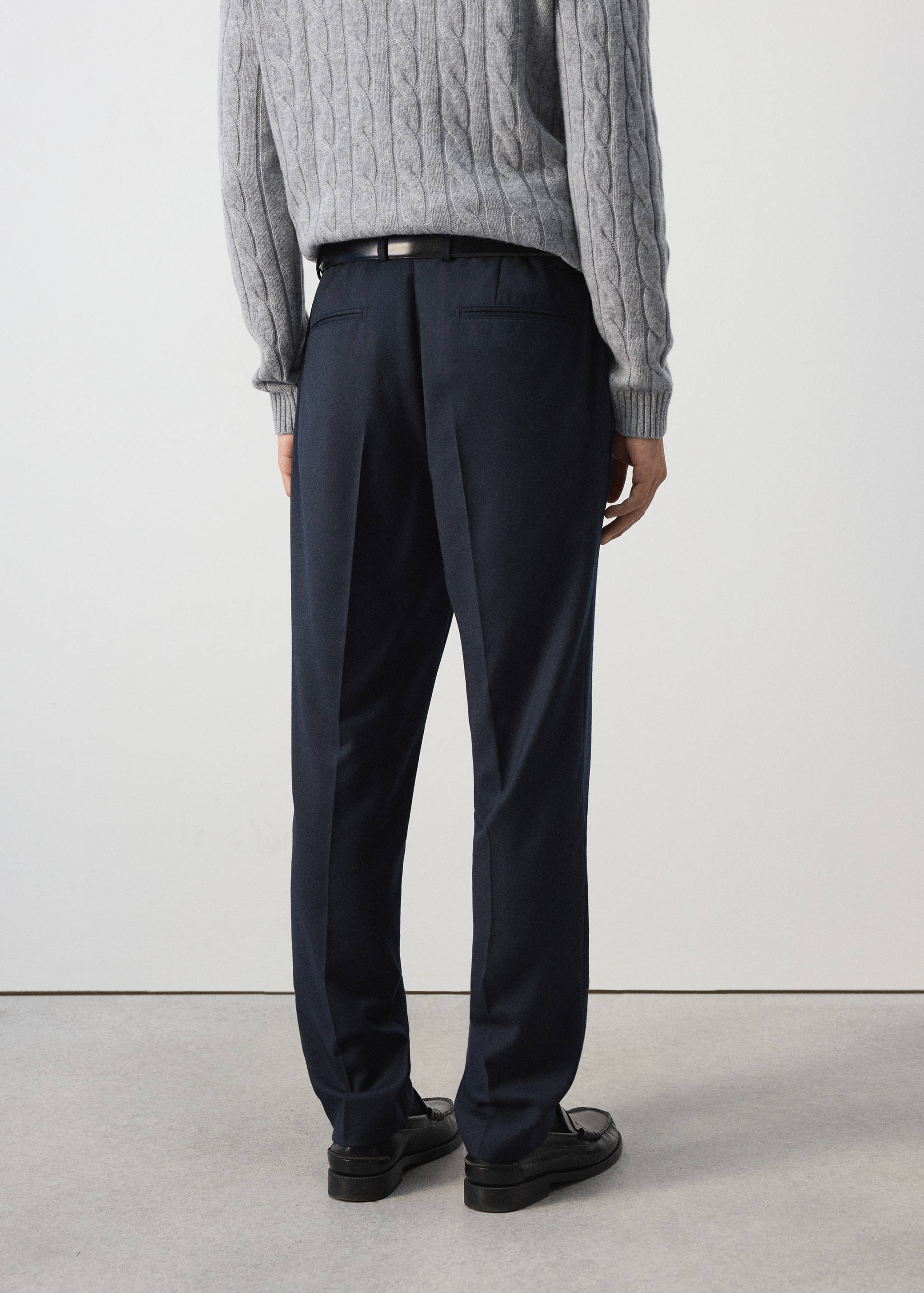 Dark navy blue trousers shown from the back, featuring back pockets and pressed creases.