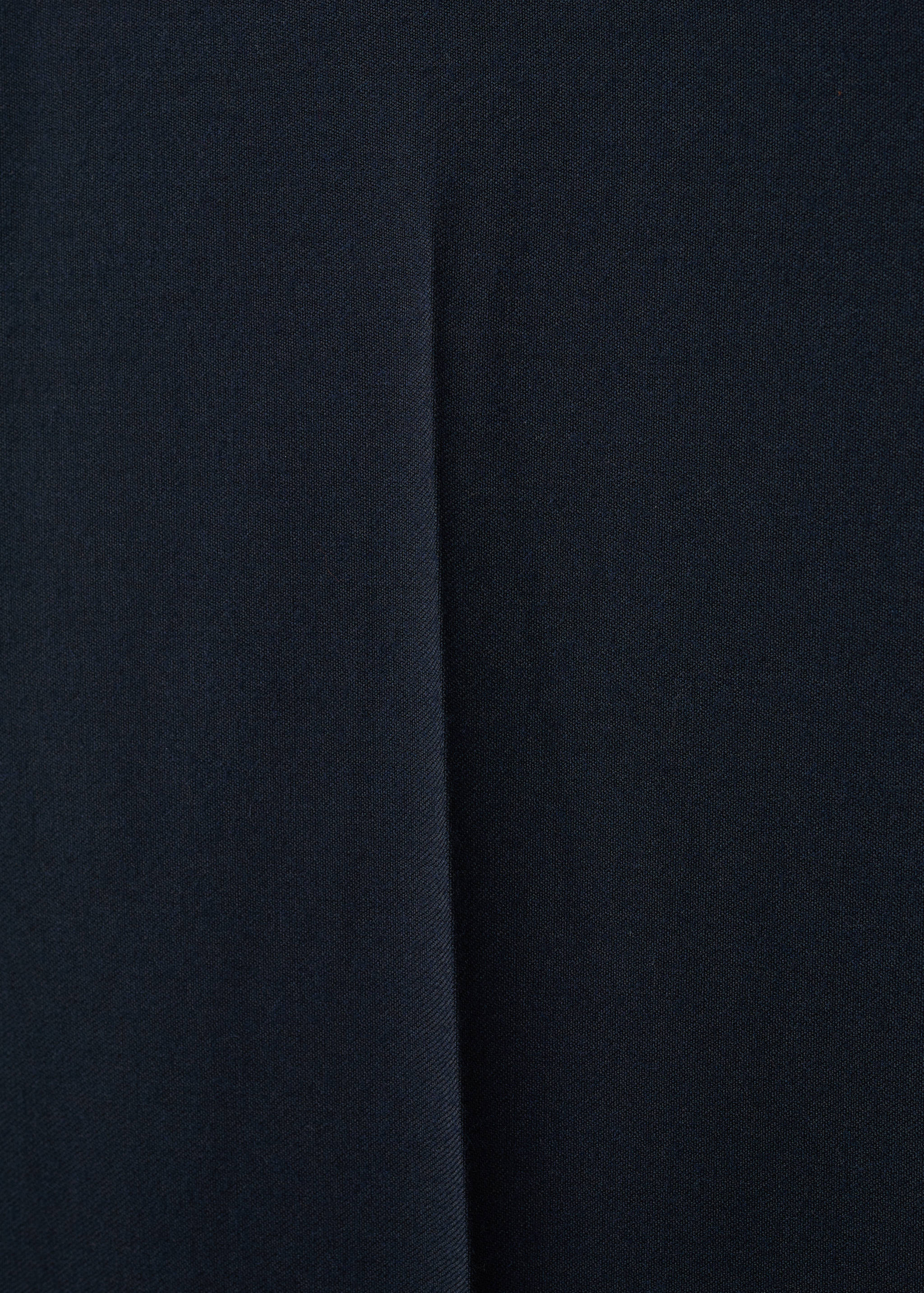 Close-up of navy blue men's trousers showing a tailored crease.