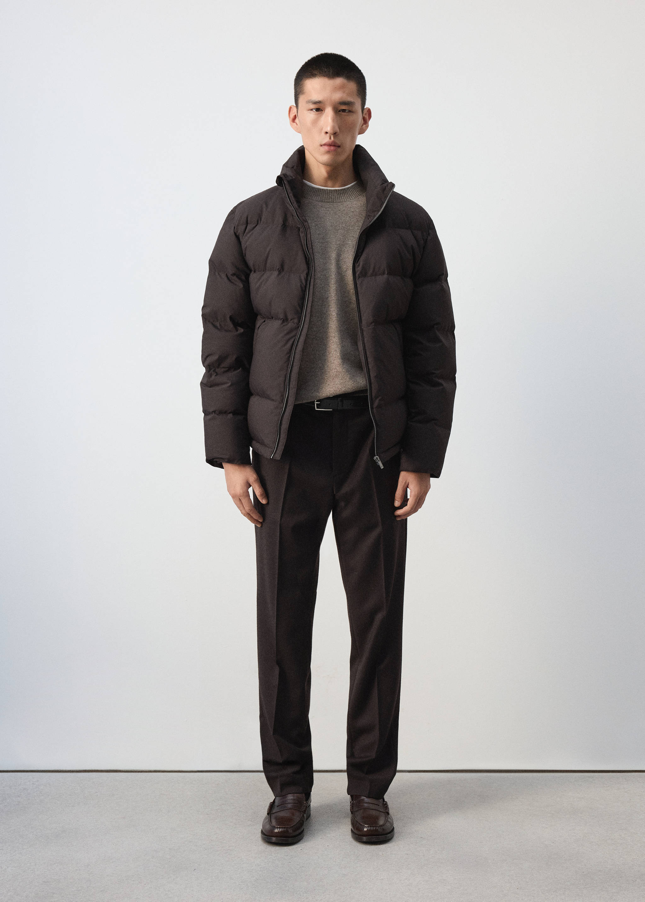 Dark brown quilted anorak with a high zip-up collar.