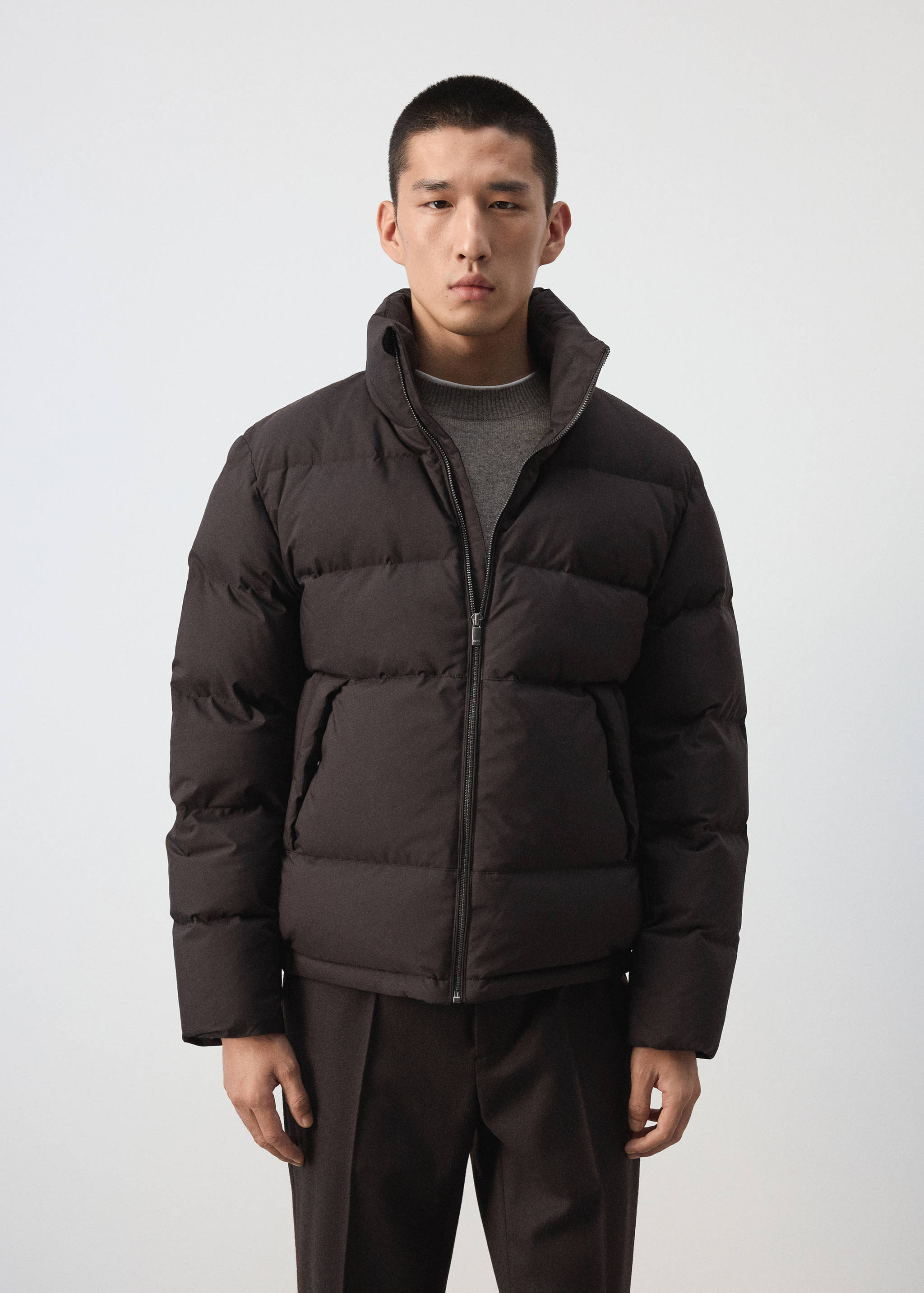 Dark brown quilted anorak with a high neck and front zip.