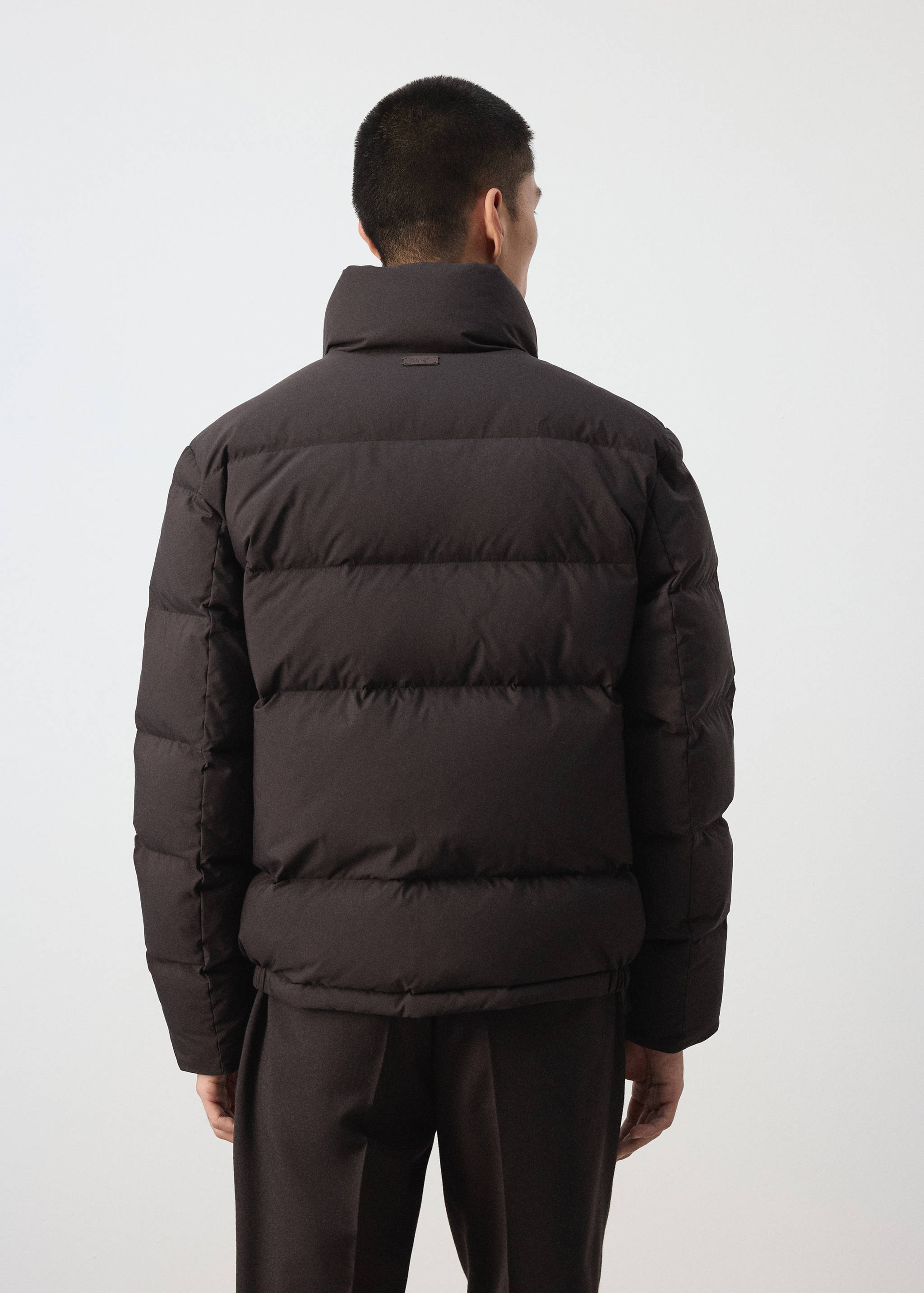 Dark brown puffer anorak with high collar, back view.