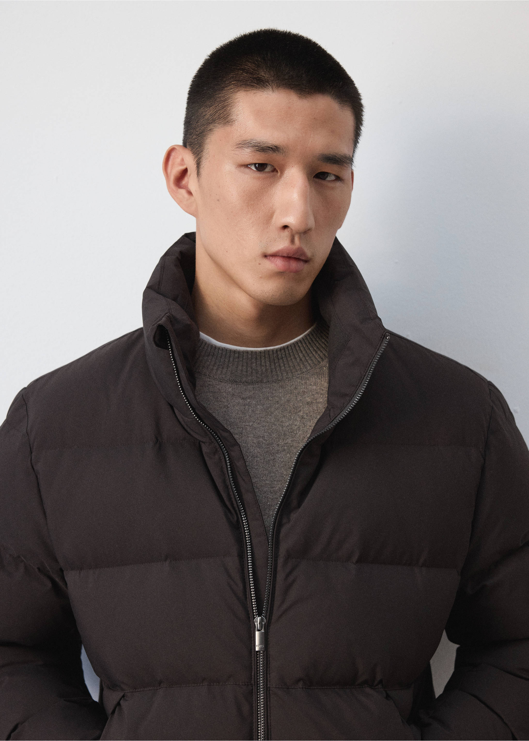 Close-up of a dark brown quilted anorak with a high neck on a male model., Chocolate. Ref: 37017887-00.