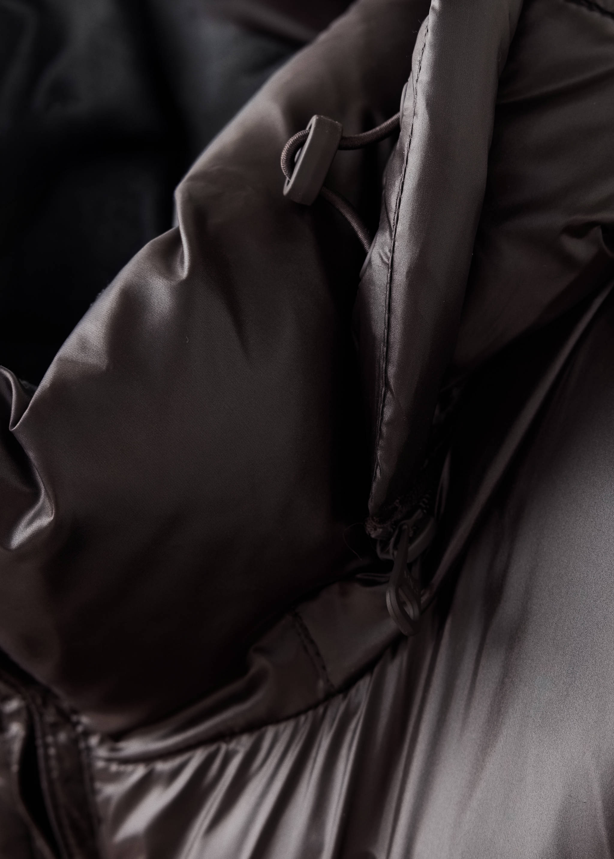 Close-up of the dark brown anorak collar and drawstring detail.