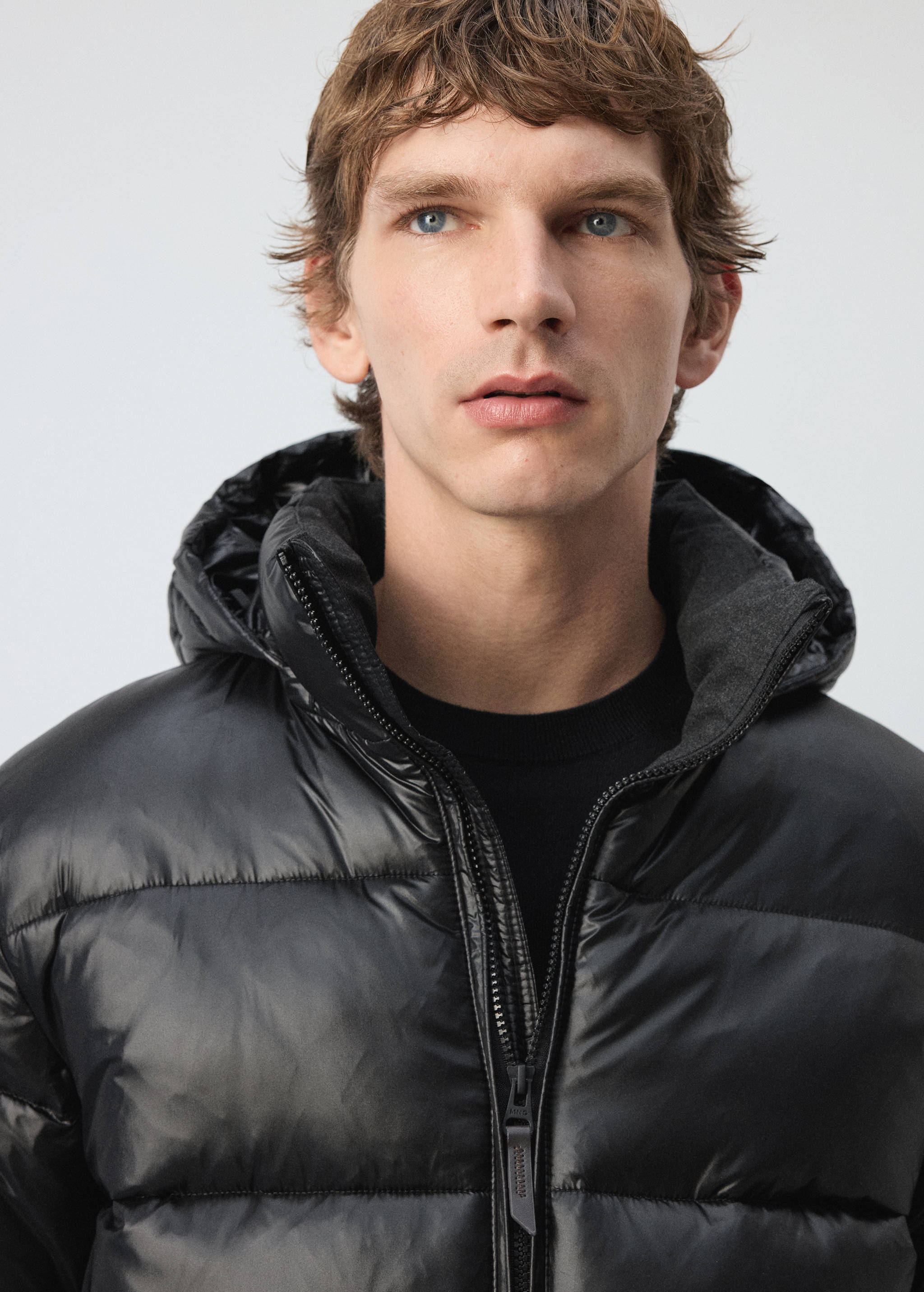 Black padded anorak with hood and zip fastening.