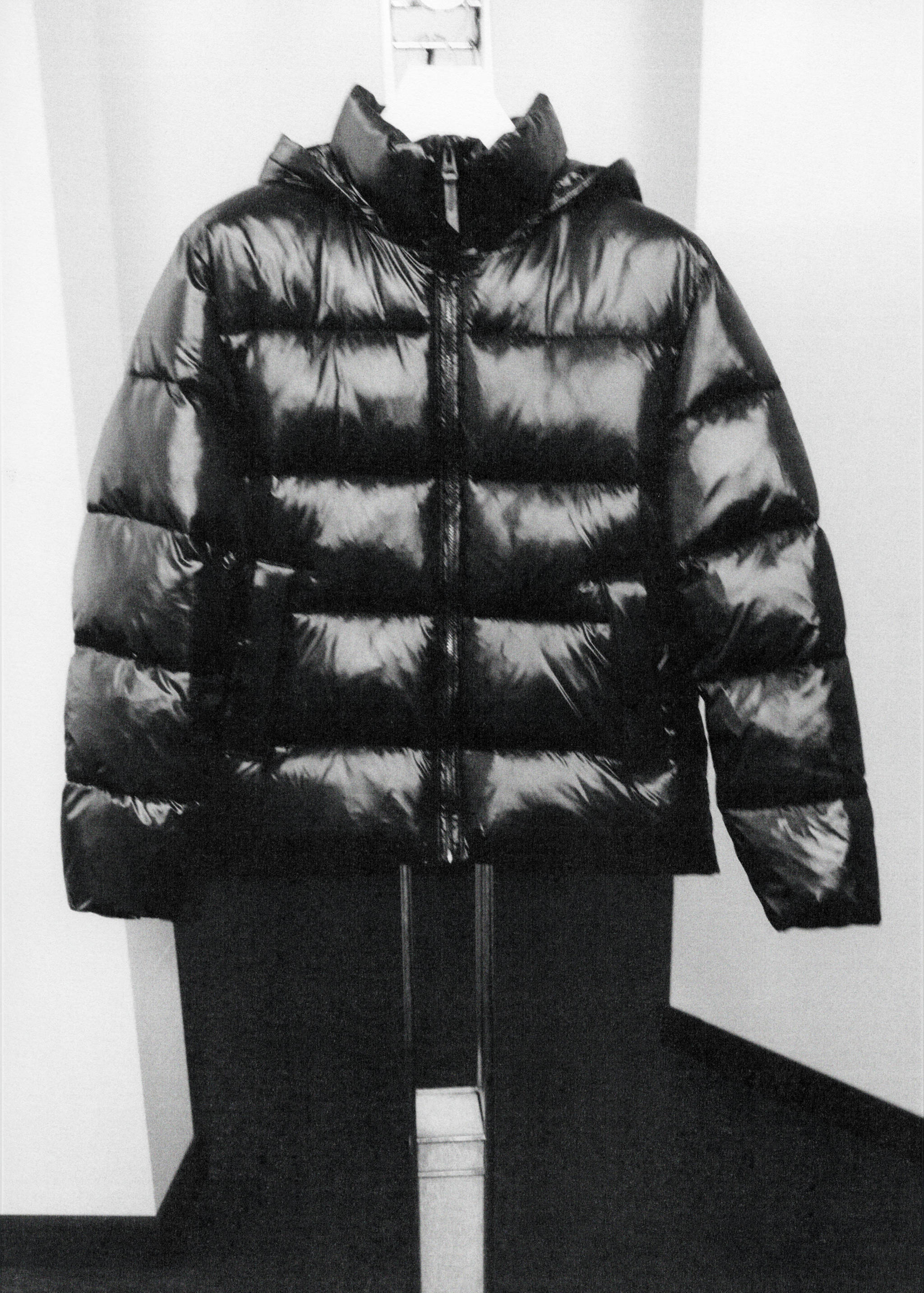 Black glossy quilted anorak with a high collar and a front zip.