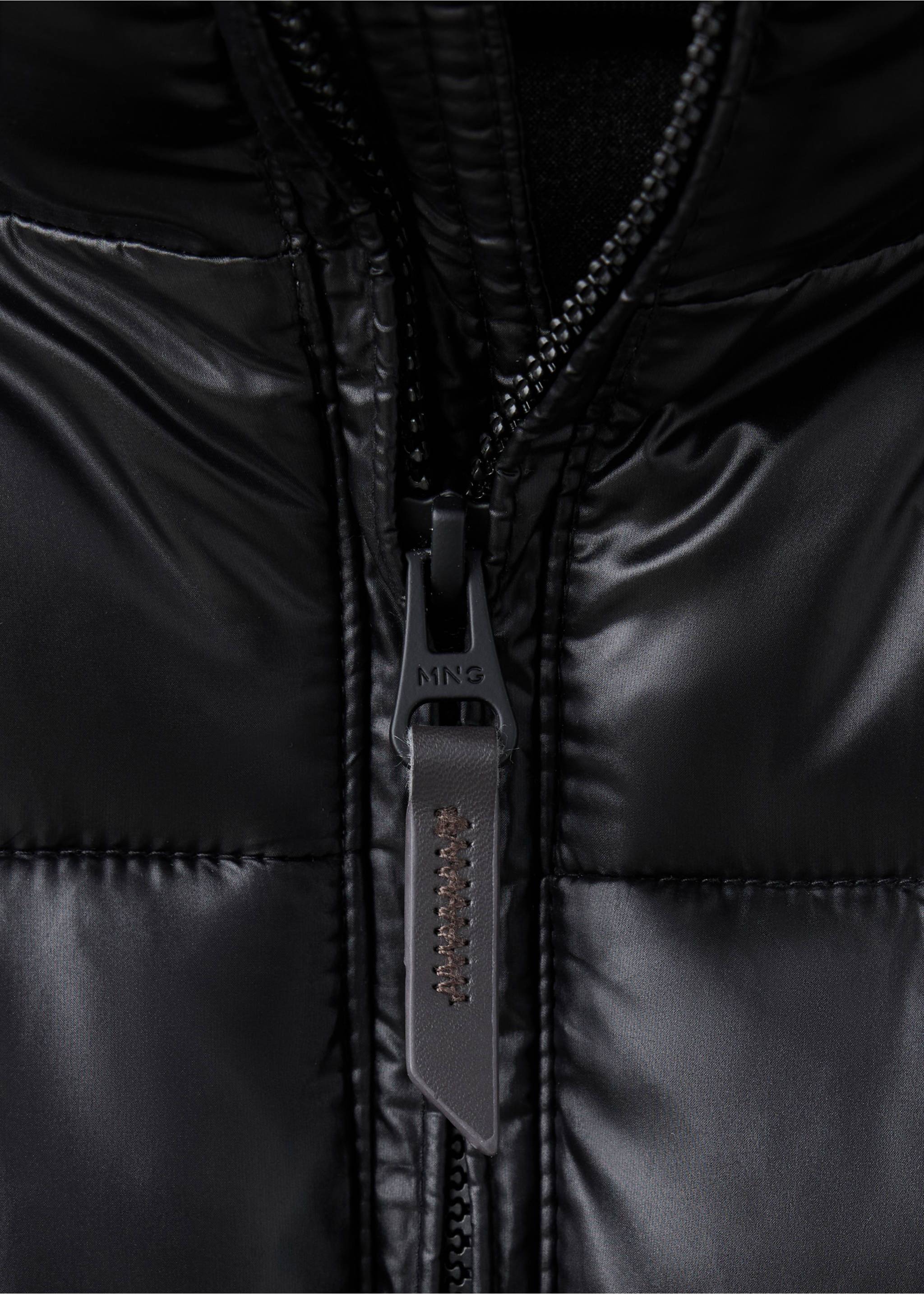 Close-up of a black anorak zipper detail with a branded MNG pull tab., Black. Ref: 37017892-00.