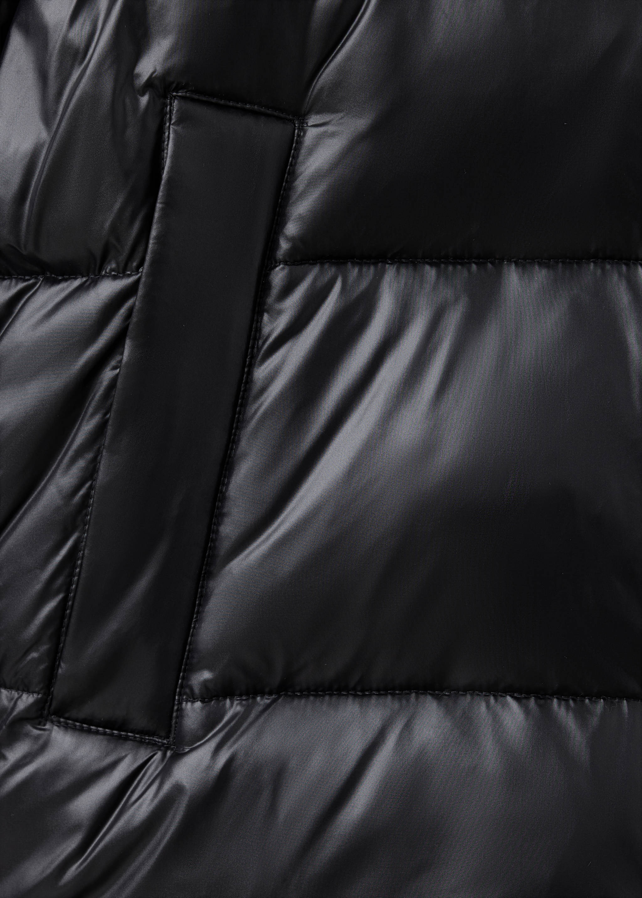 Close-up of black quilted anorak fabric and pocket.
