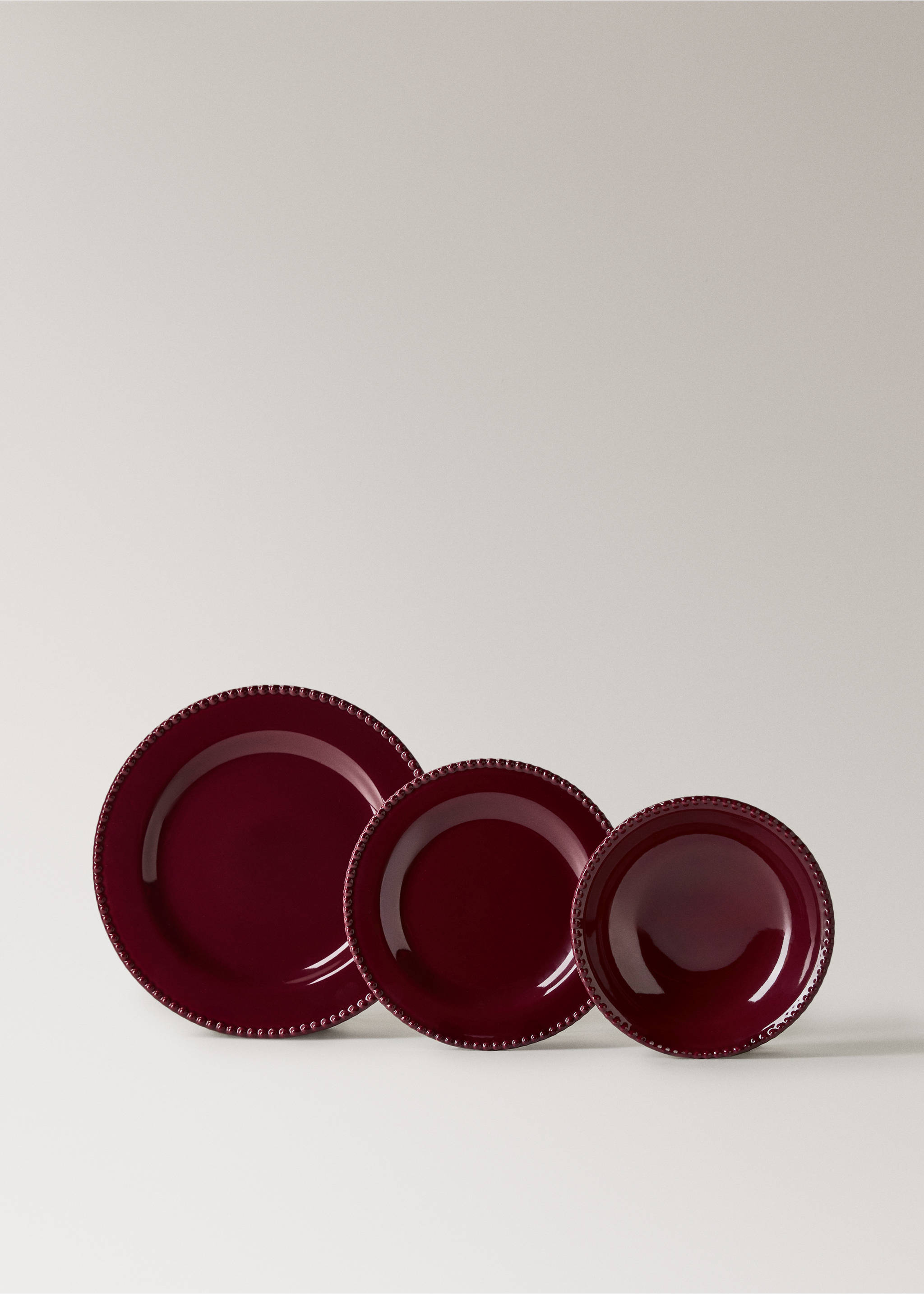 Burgundy ceramic plates with a textured beaded rim, shown in three sizes., Red. Ref: 37017899-00.
