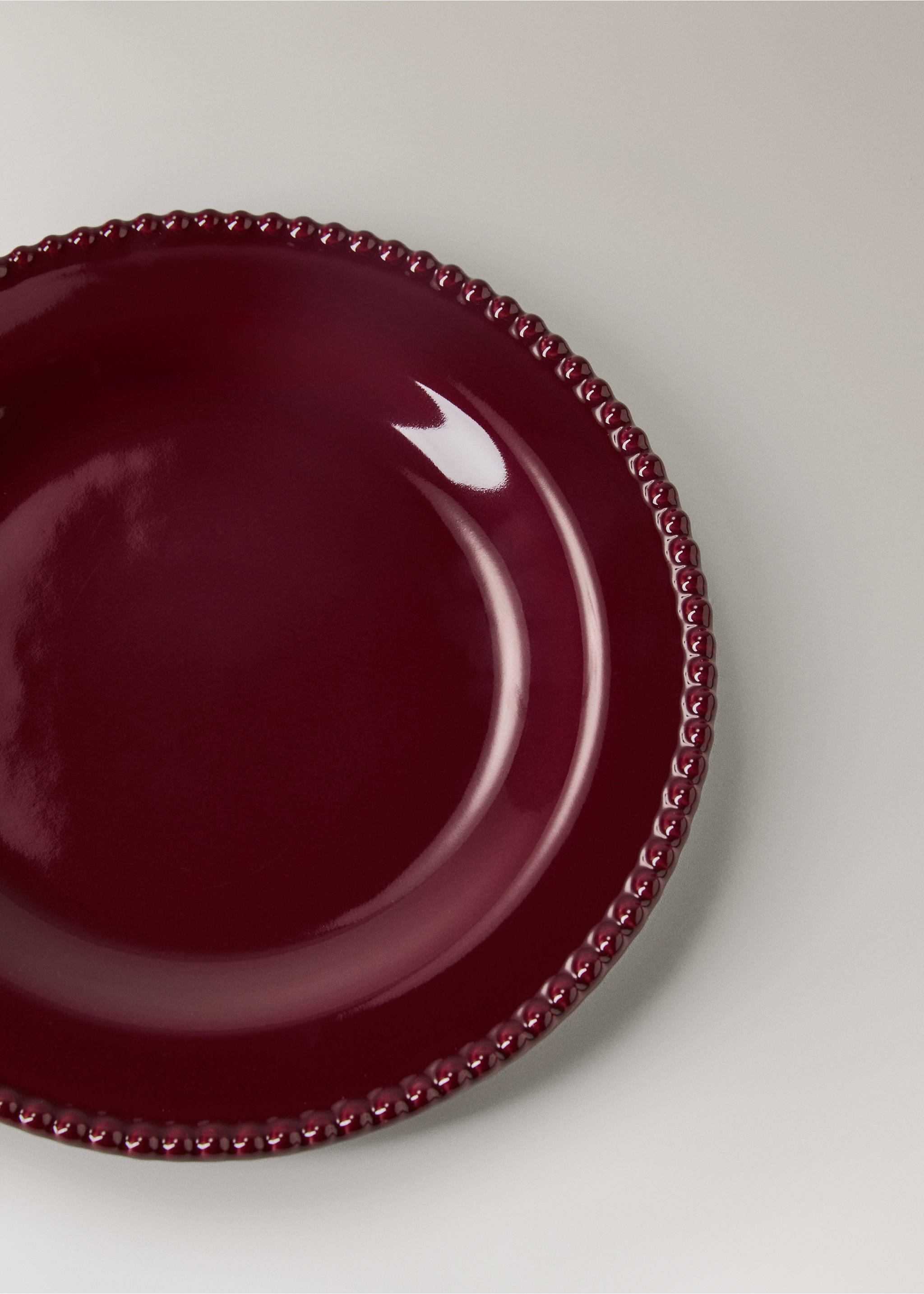 Burgundy ceramic plate with a glossy finish and beaded rim detail., Red. Ref: 37017900-00.