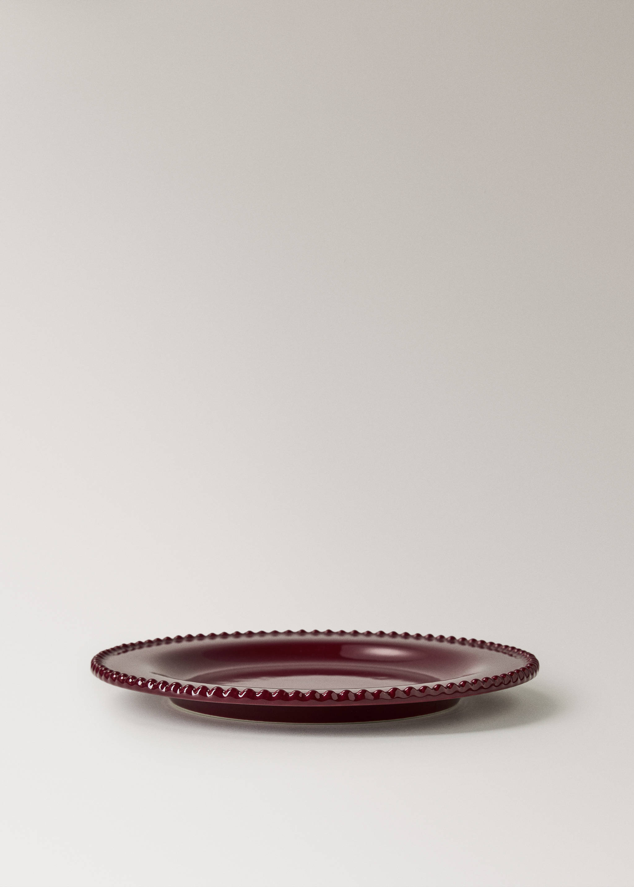 Burgundy plate with a glossy finish and a raised beaded rim detail.