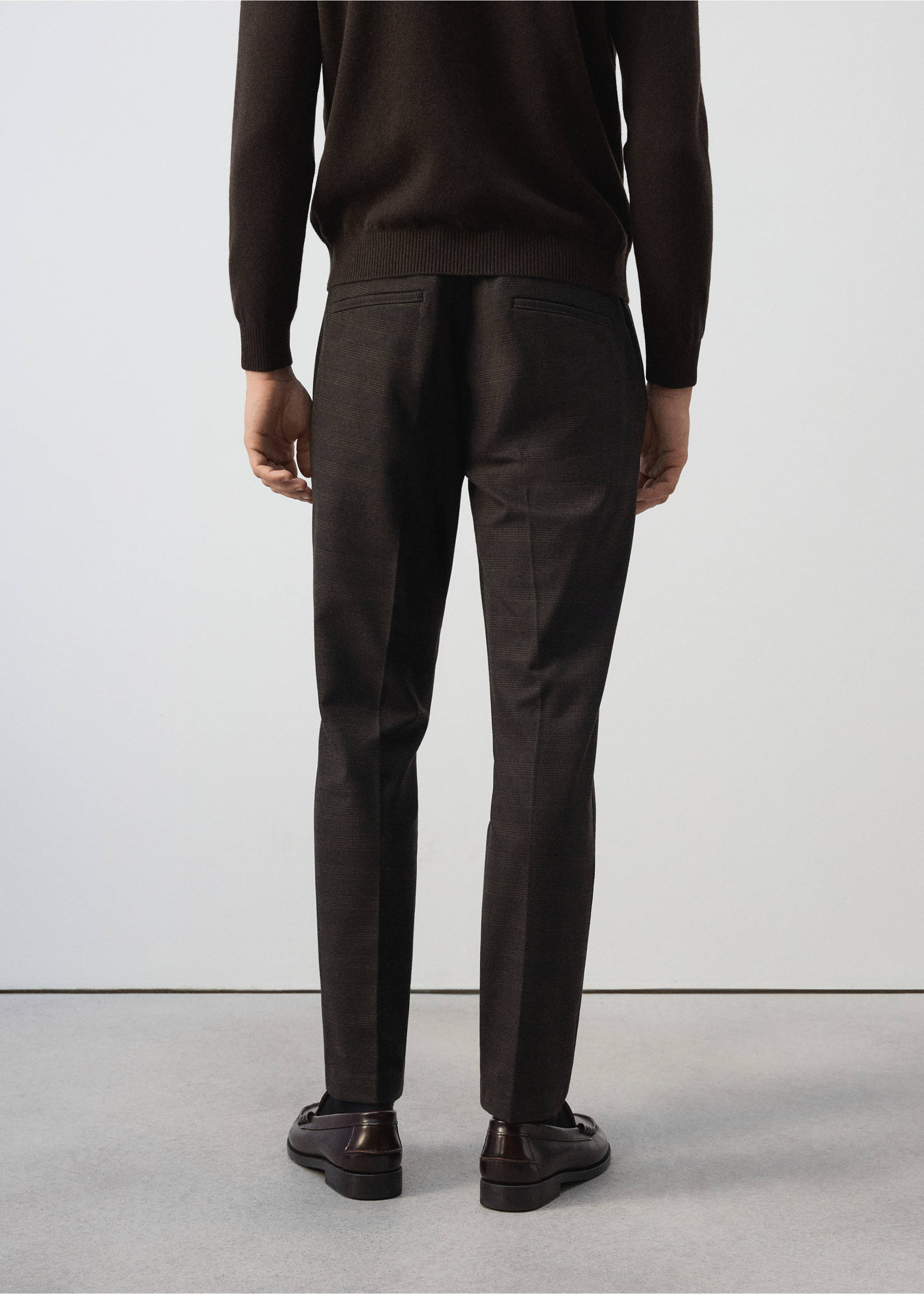Dark brown trousers from the back view, showing pressed creases and rear welt pockets., Chocolate. Ref: 37017902-00.