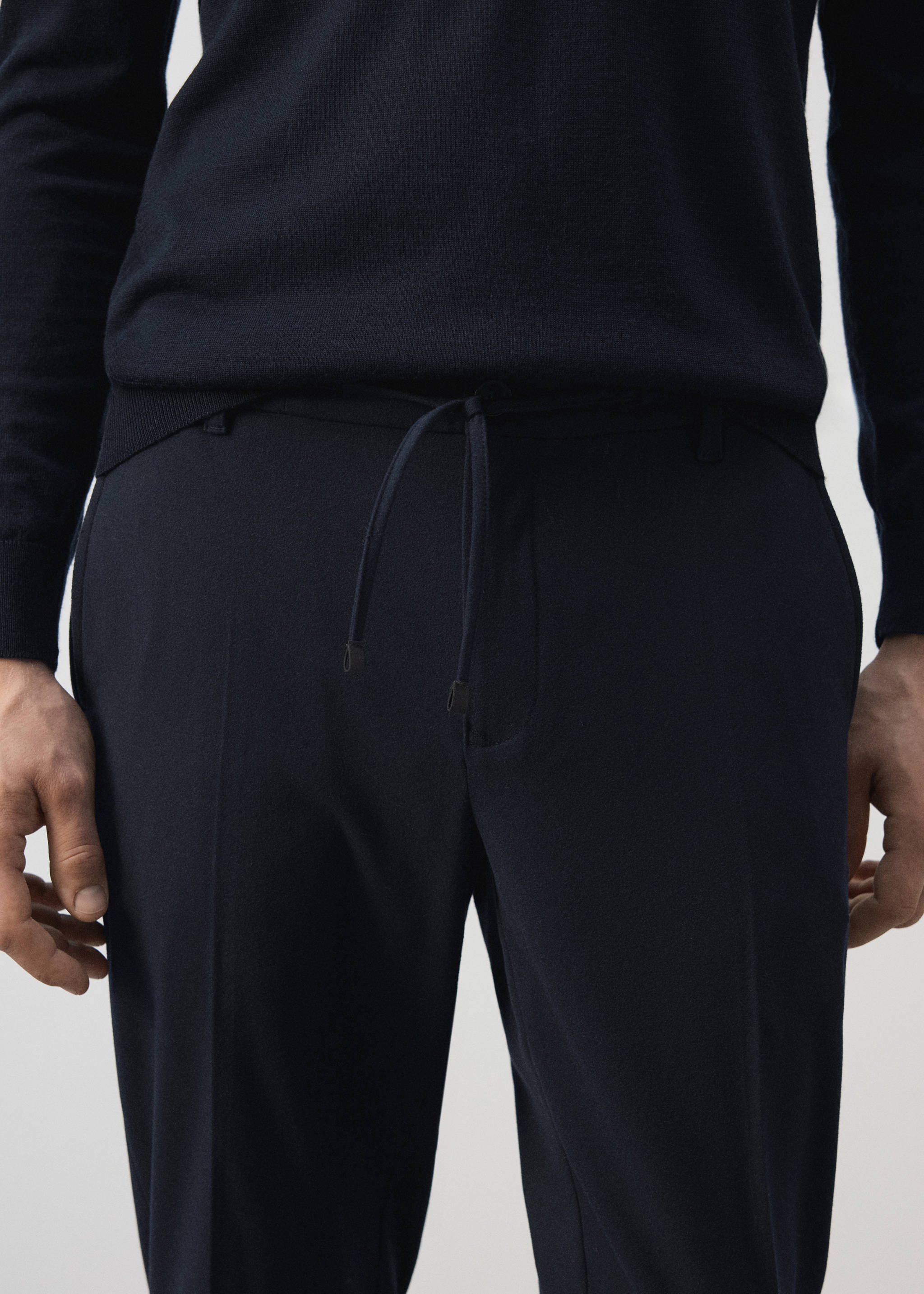 Dark navy blue tailored trousers with a drawstring waistband.