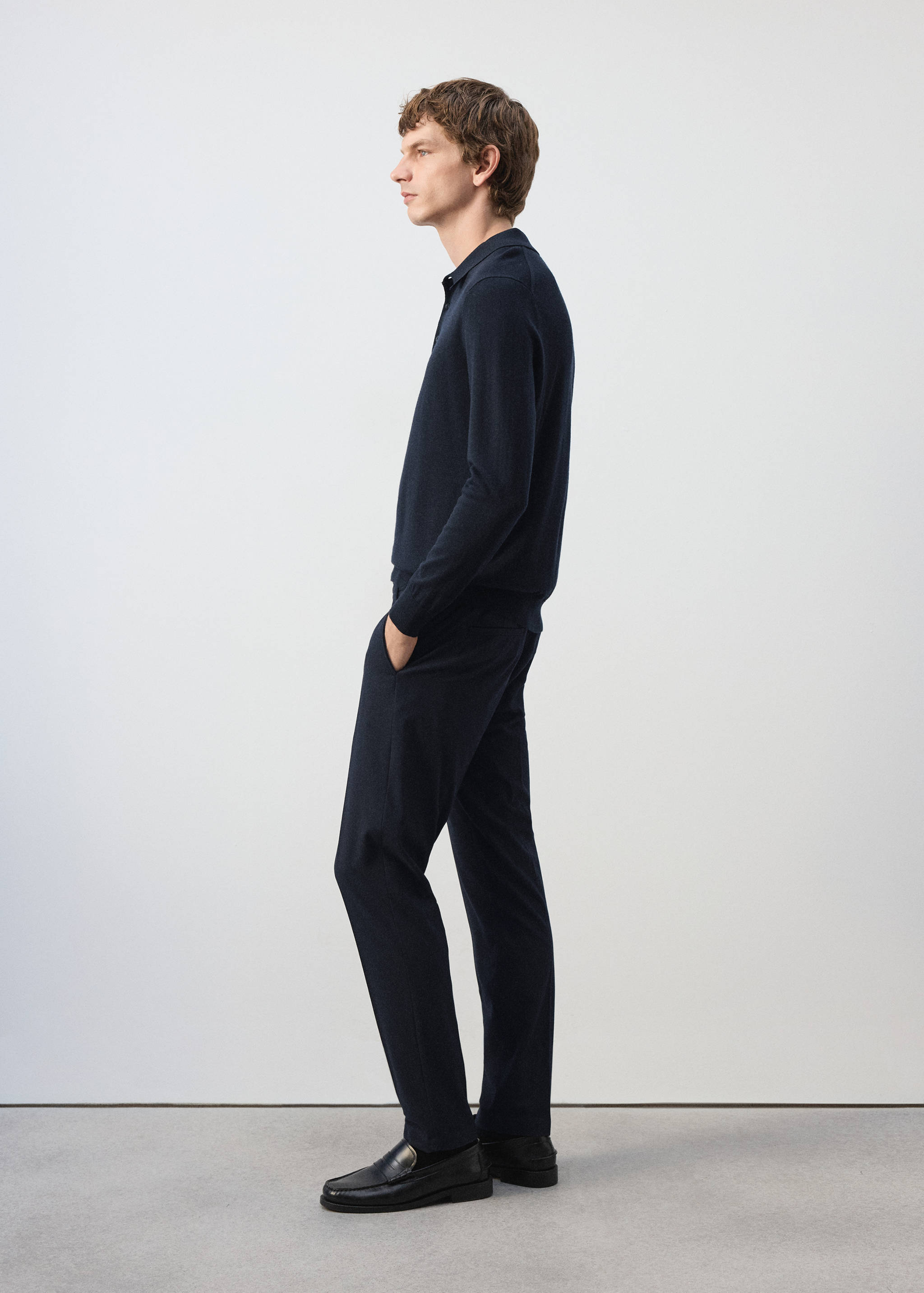 Dark navy blue straight trousers worn with a matching polo sweater.