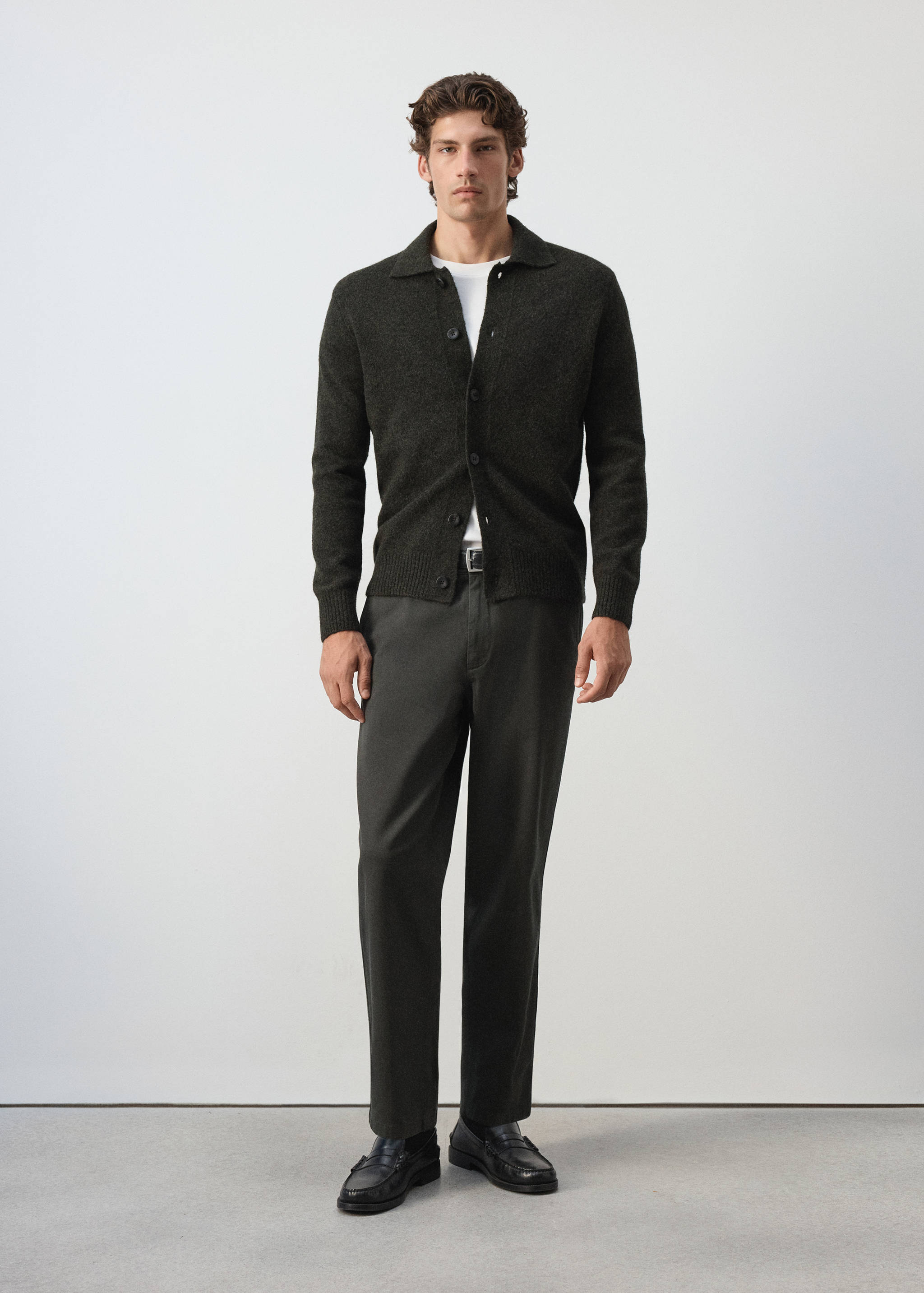 Dark charcoal straight-leg trousers, styled with a dark green cardigan and white t-shirt.