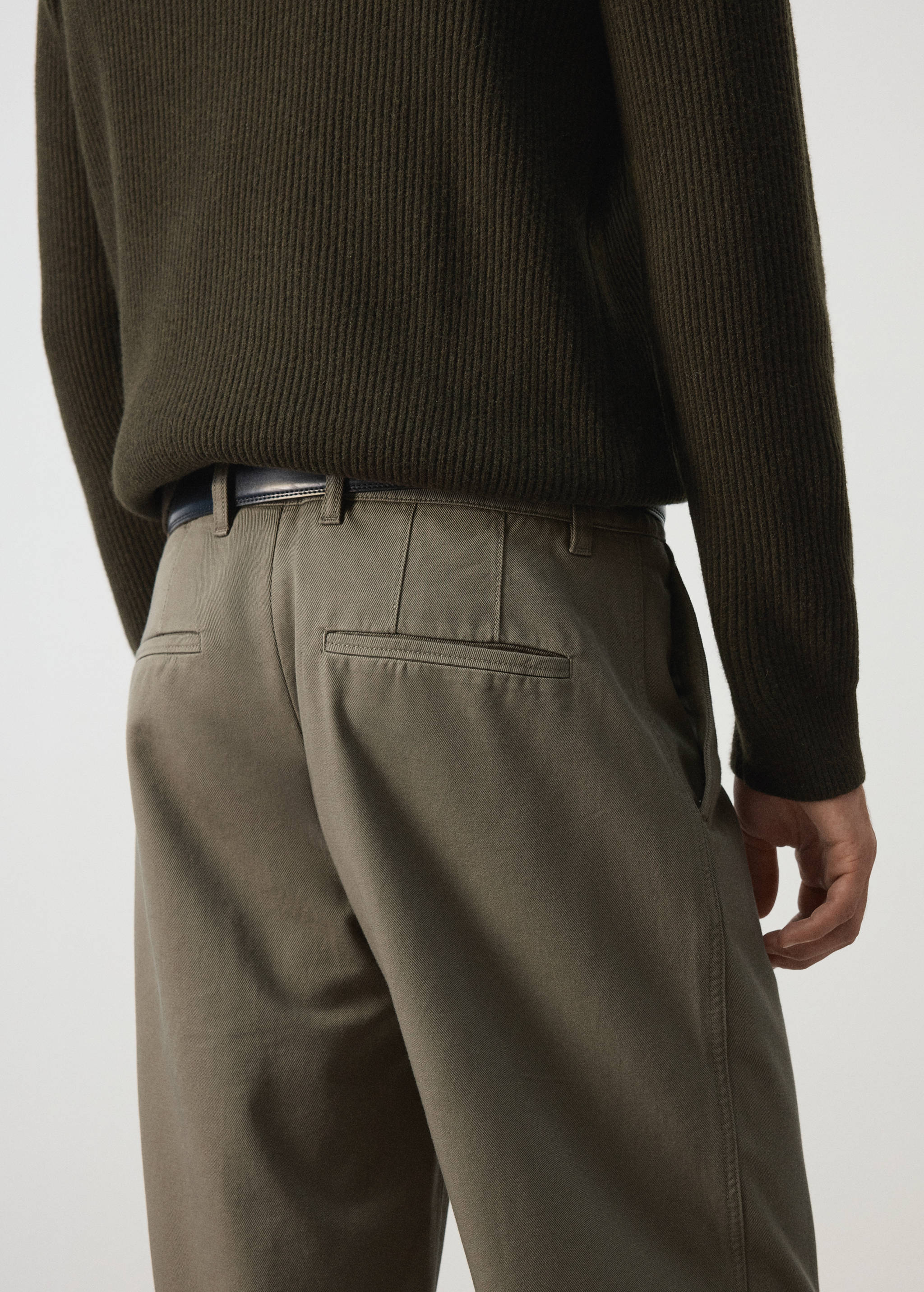 Khaki trousers, back view, worn with a dark olive green ribbed sweater.