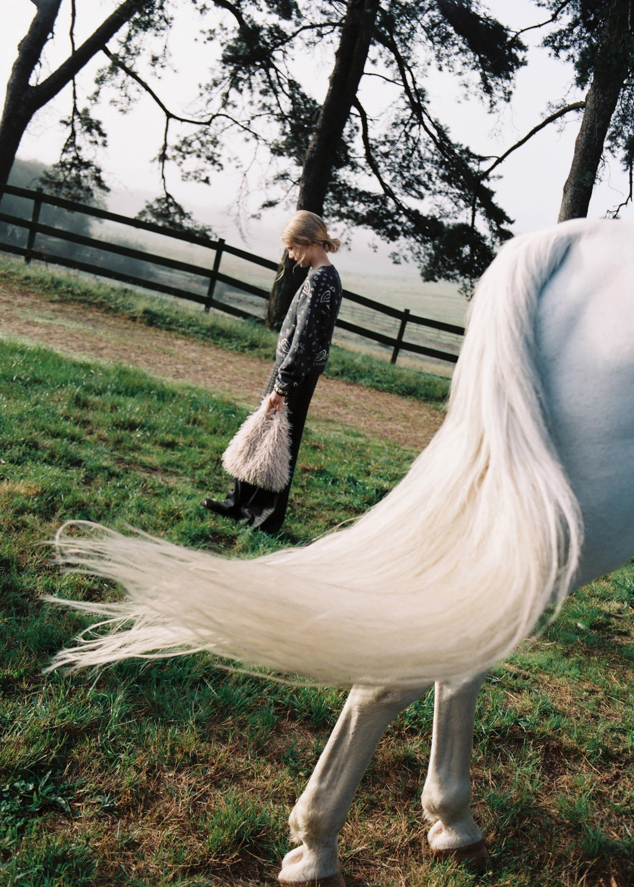 Textured light grey mini bag with long fringe, held by a child outdoors.