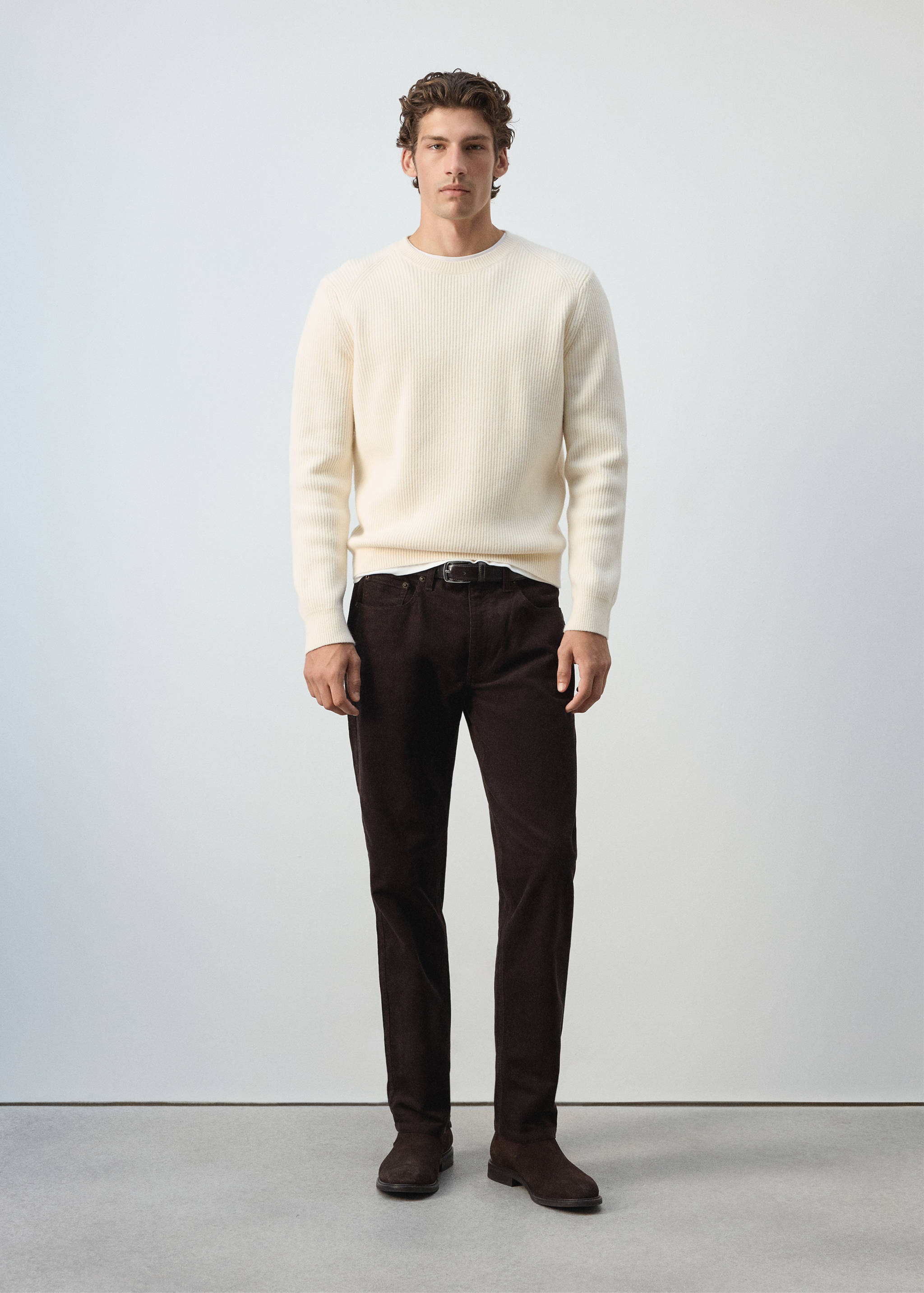 Cream ribbed crew neck jumper worn with brown trousers.