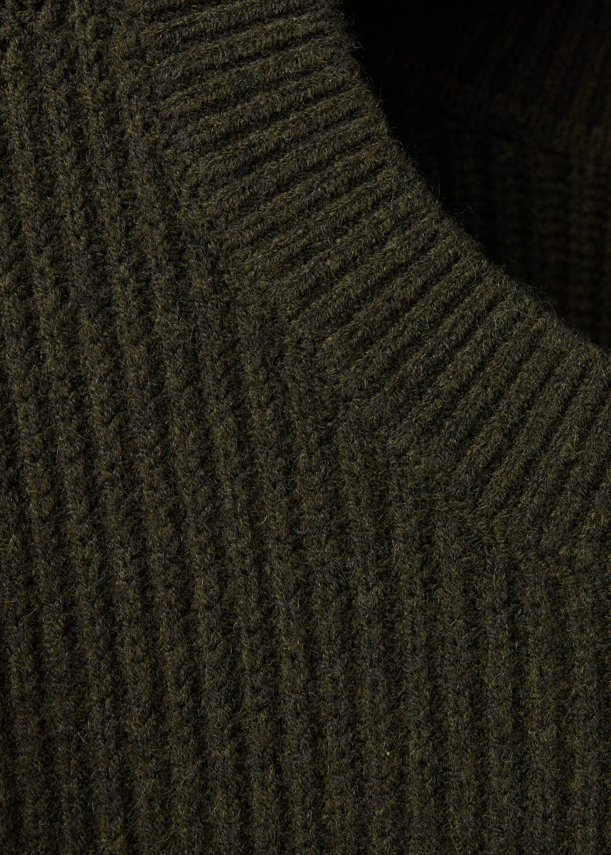 Close-up of a dark green ribbed knit jersey crew neckline.