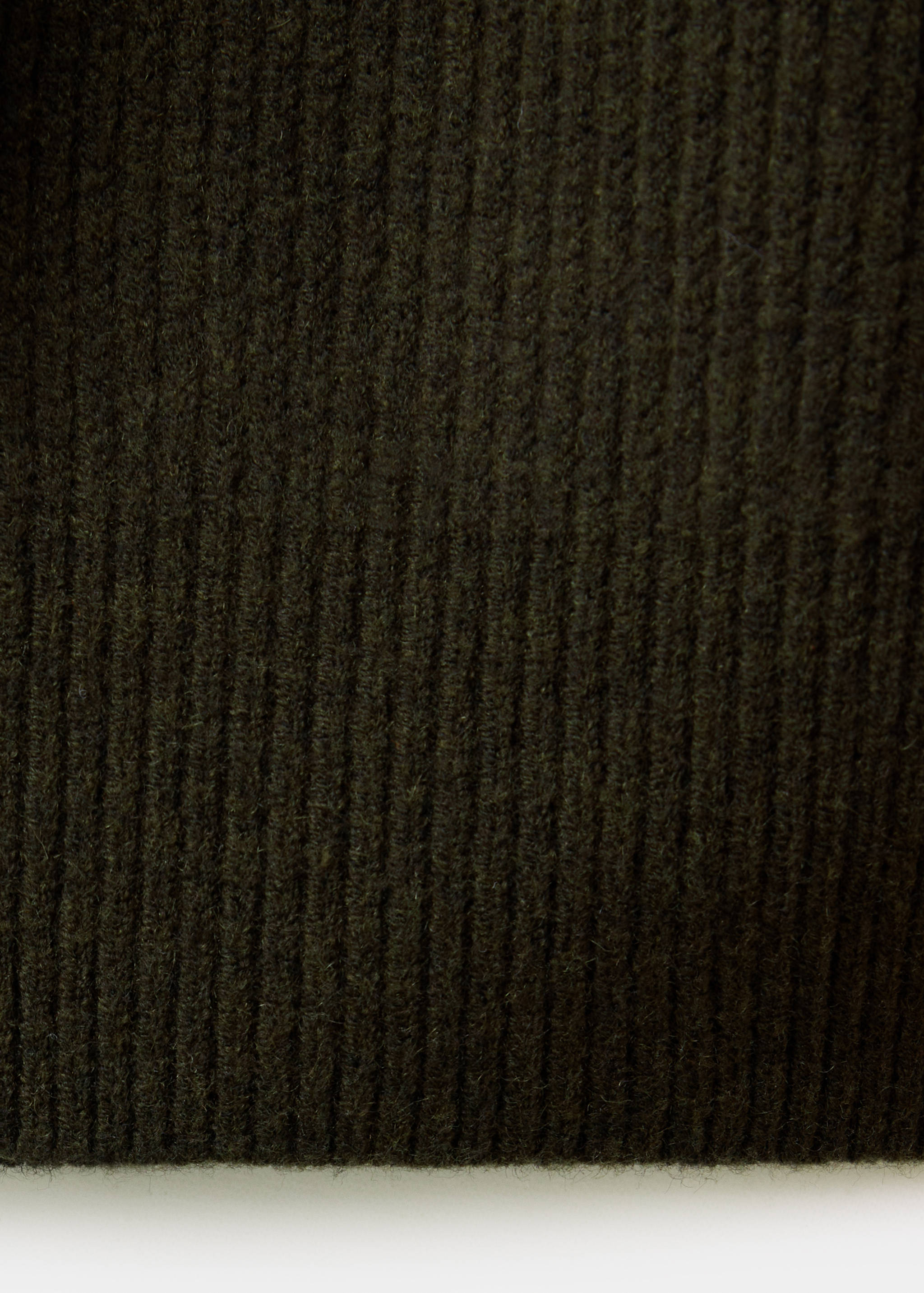Close-up of the dark green ribbed knit fabric texture on a men's jersey.