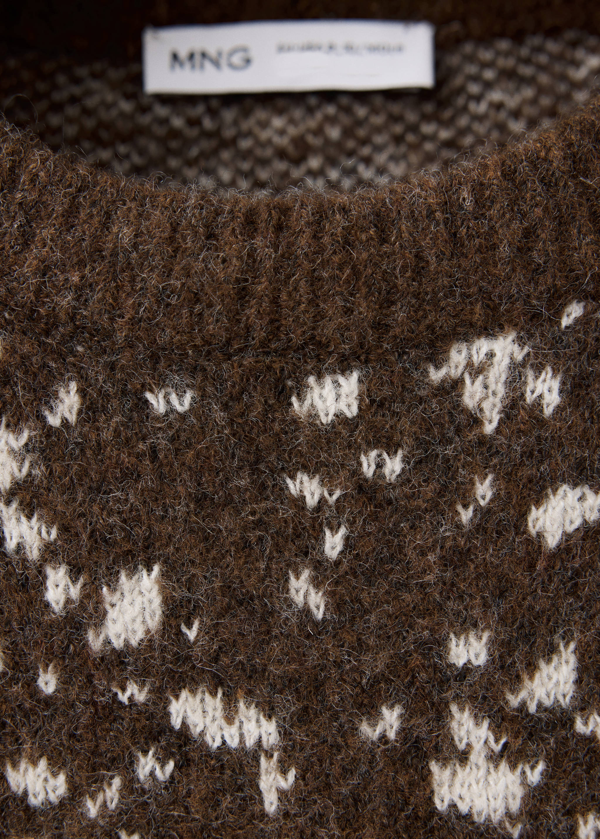 Brown knitted children's sweater detail with a fuzzy texture and white pattern.