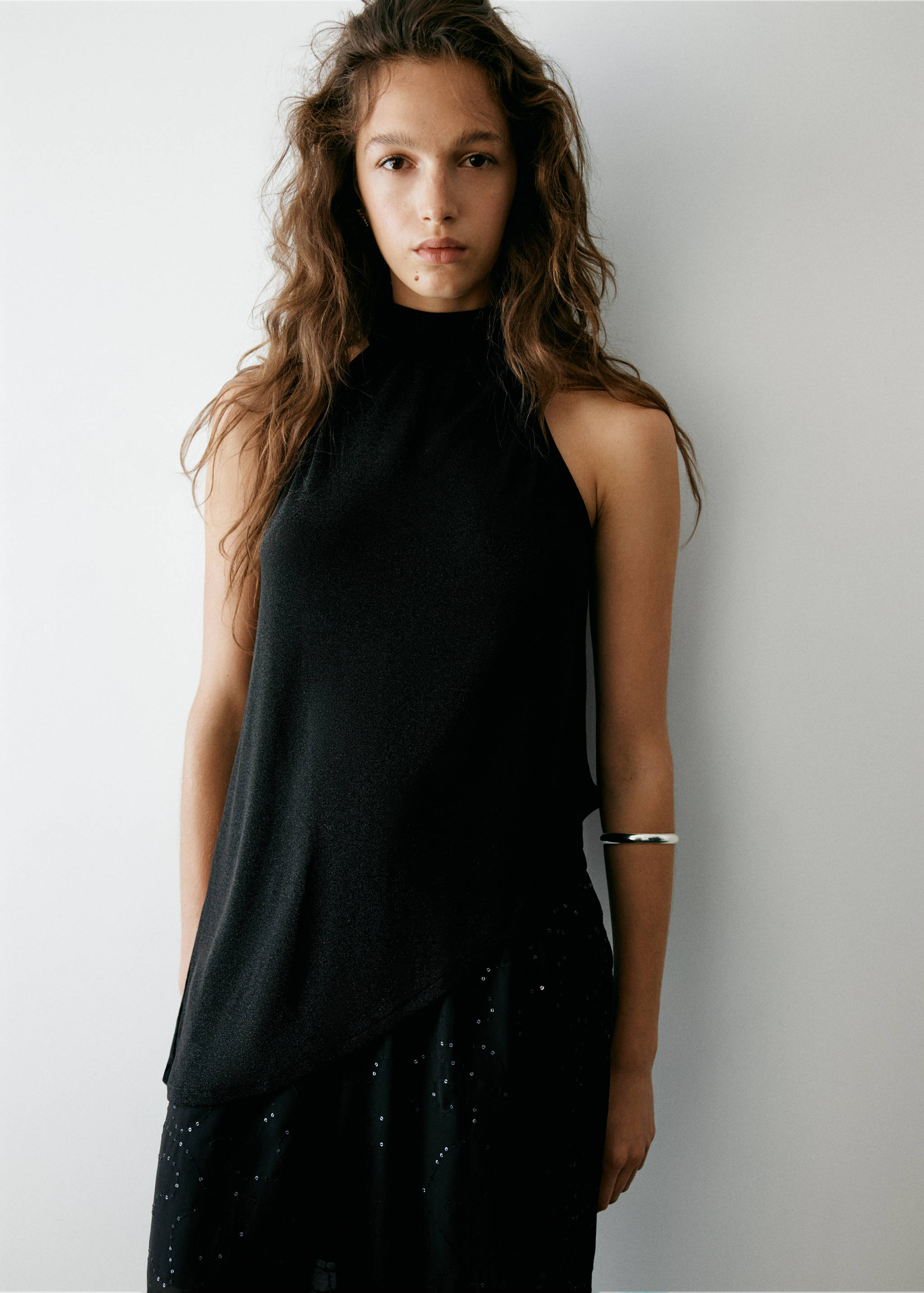 Black sleeveless halter-neck top with an asymmetric hem.