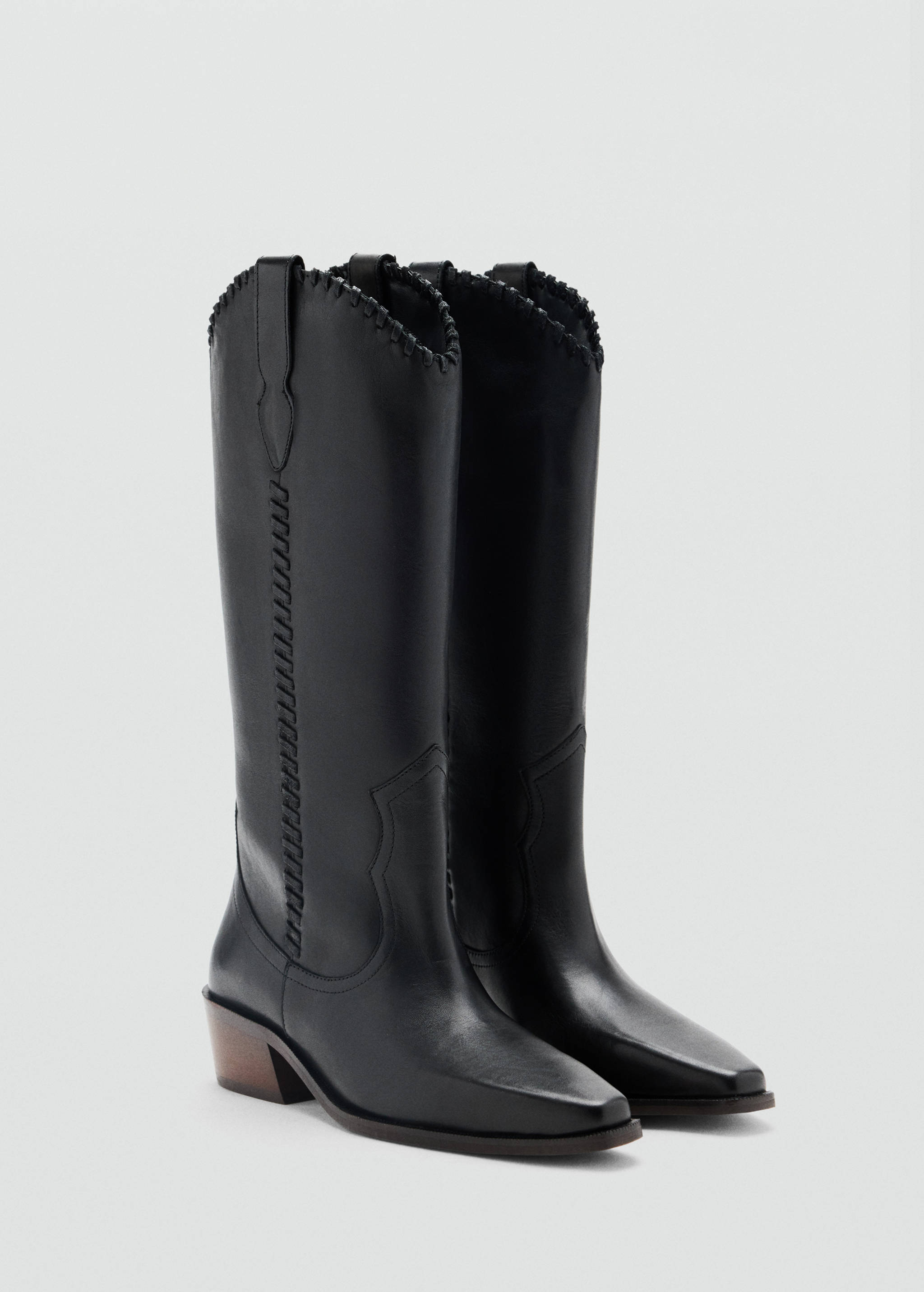 Black knee-high cowboy boots with pointed toes and block heels.
