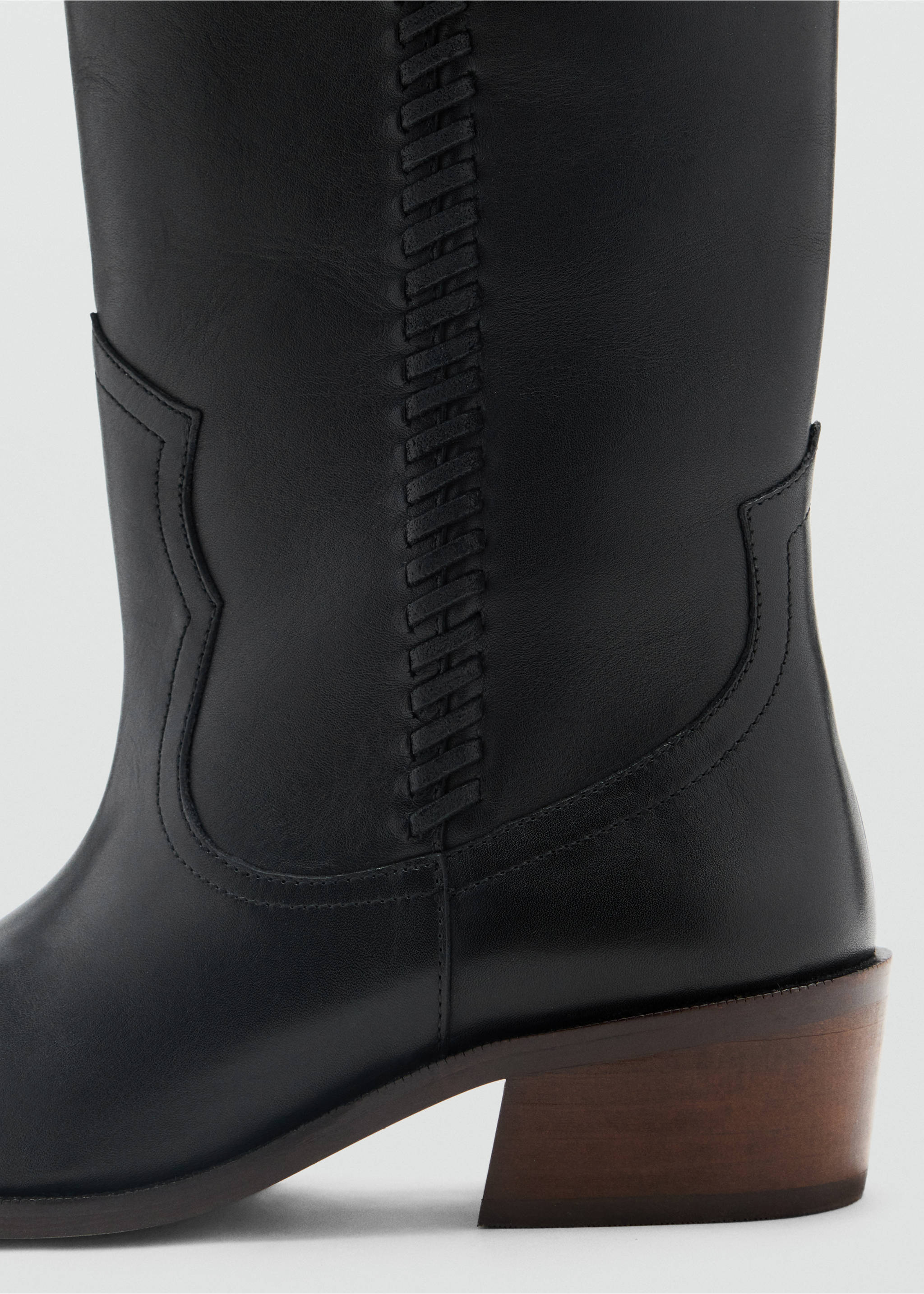 Close-up of a black boot featuring vertical whipstitching and western-style seams., Black. Ref: 37017937-00.