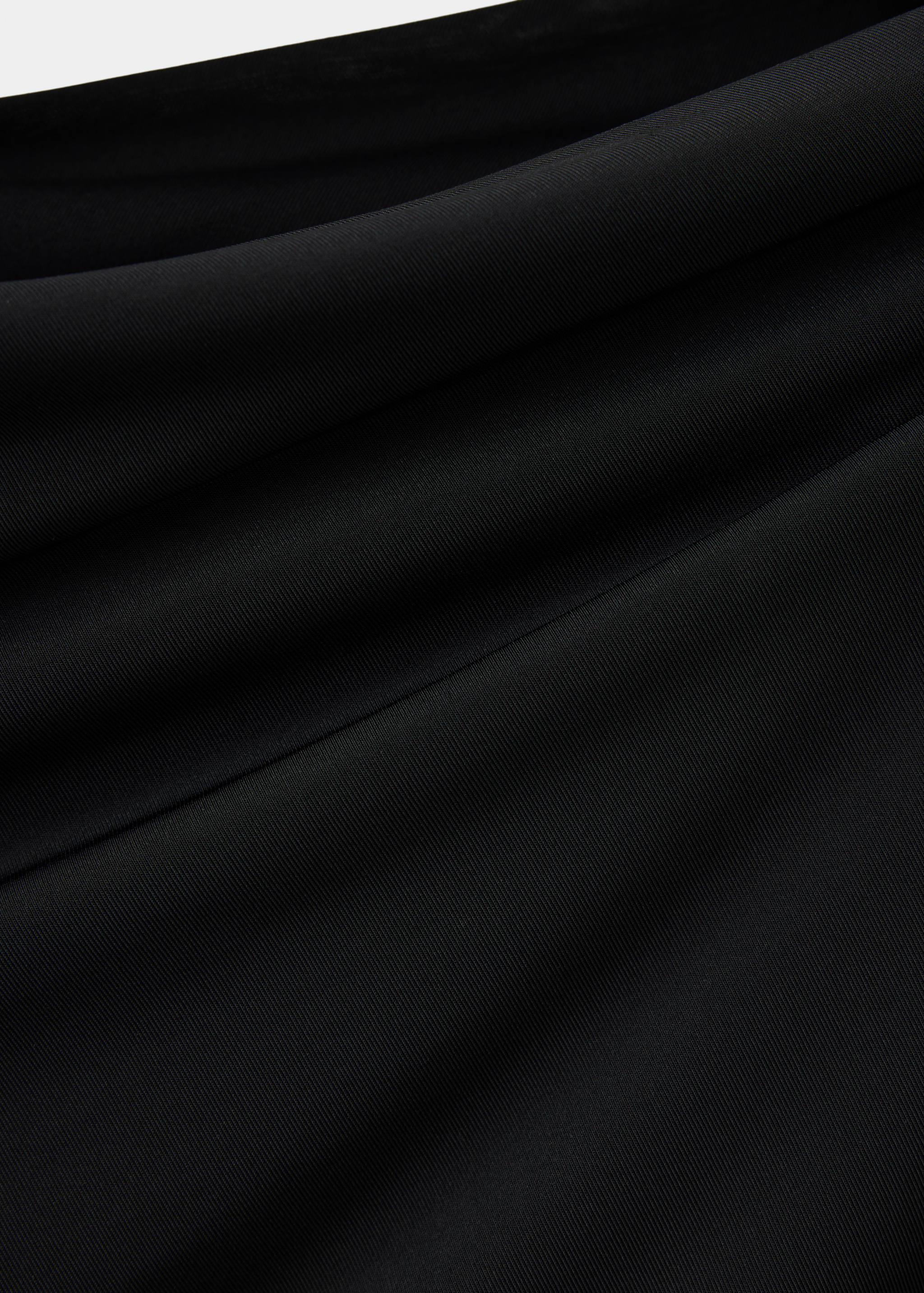 Close-up of the smooth black fabric texture on a dress.