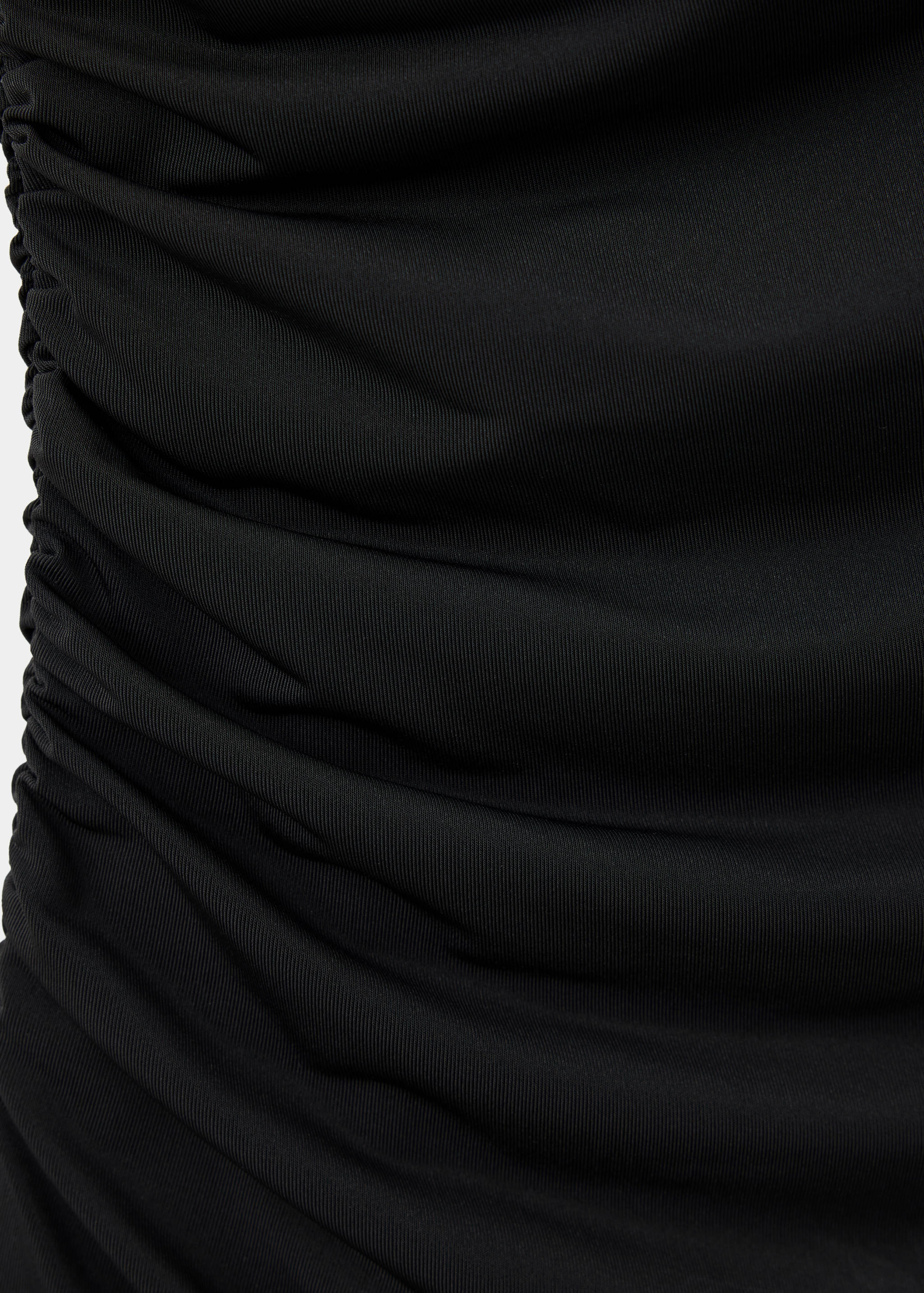 Close-up of the black dress fabric, showing ruched texture.