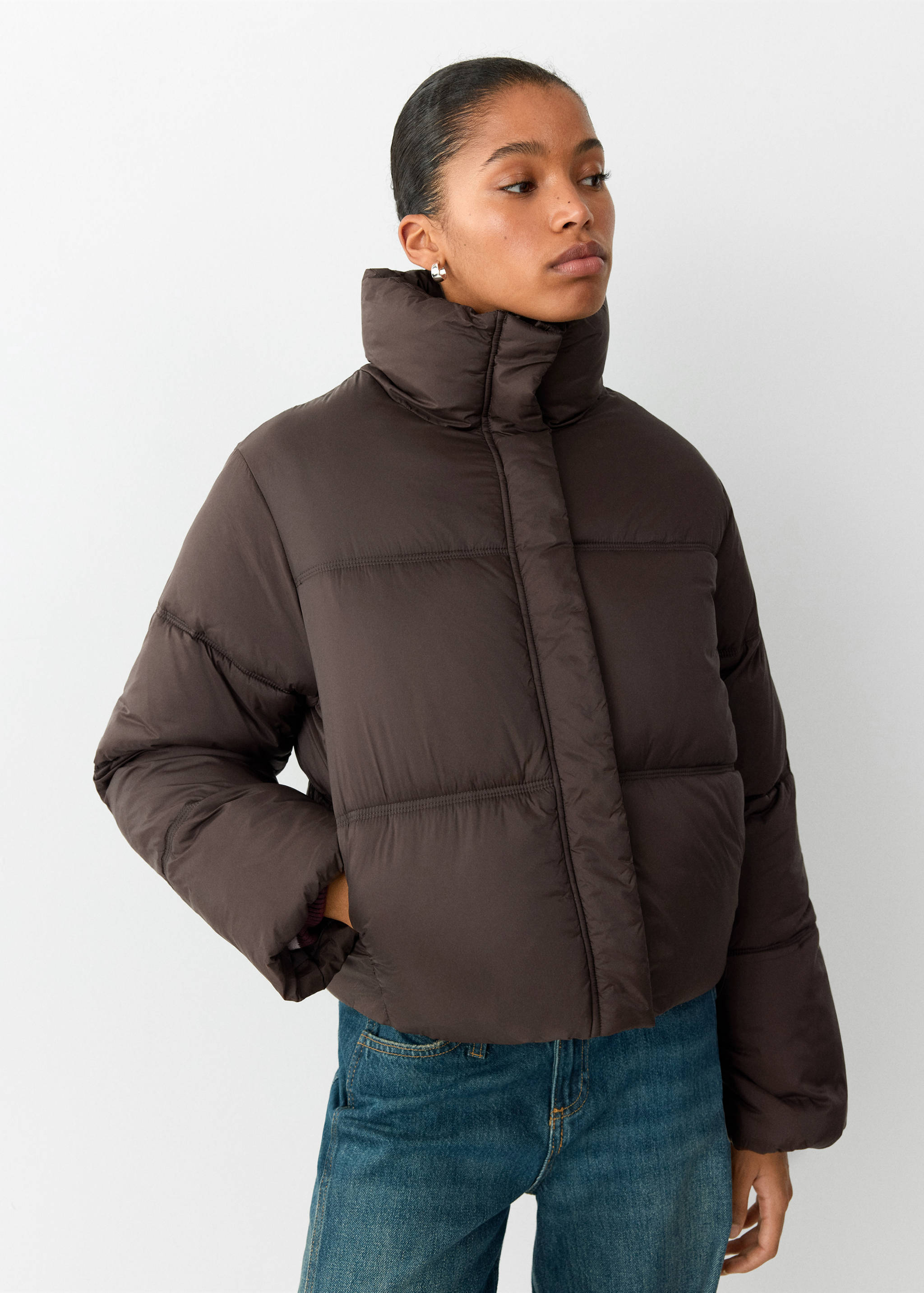 Dark brown quilted anorak with a high neck and cropped fit.
