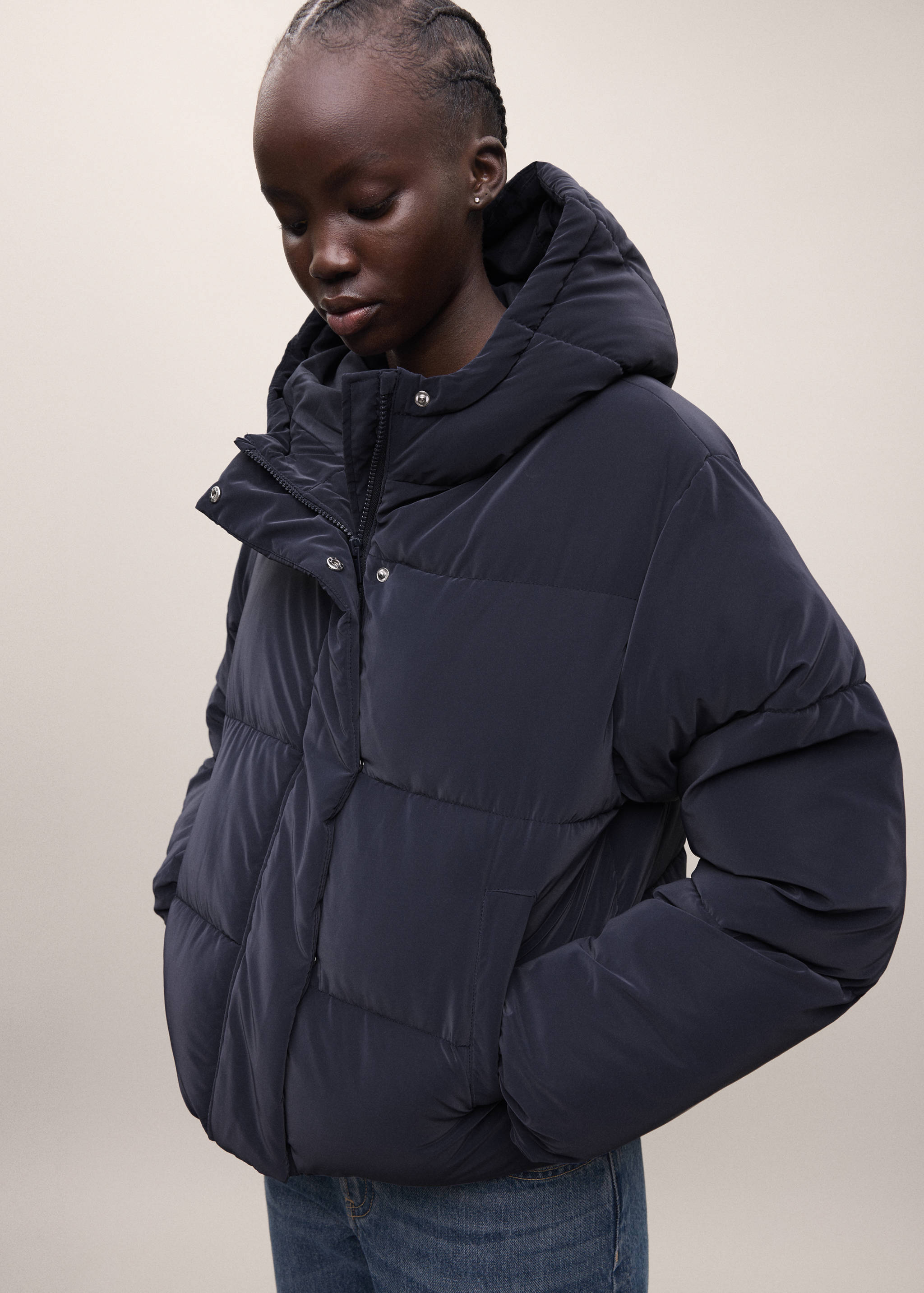 Dark navy blue quilted padded anorak with a high neck and hood.