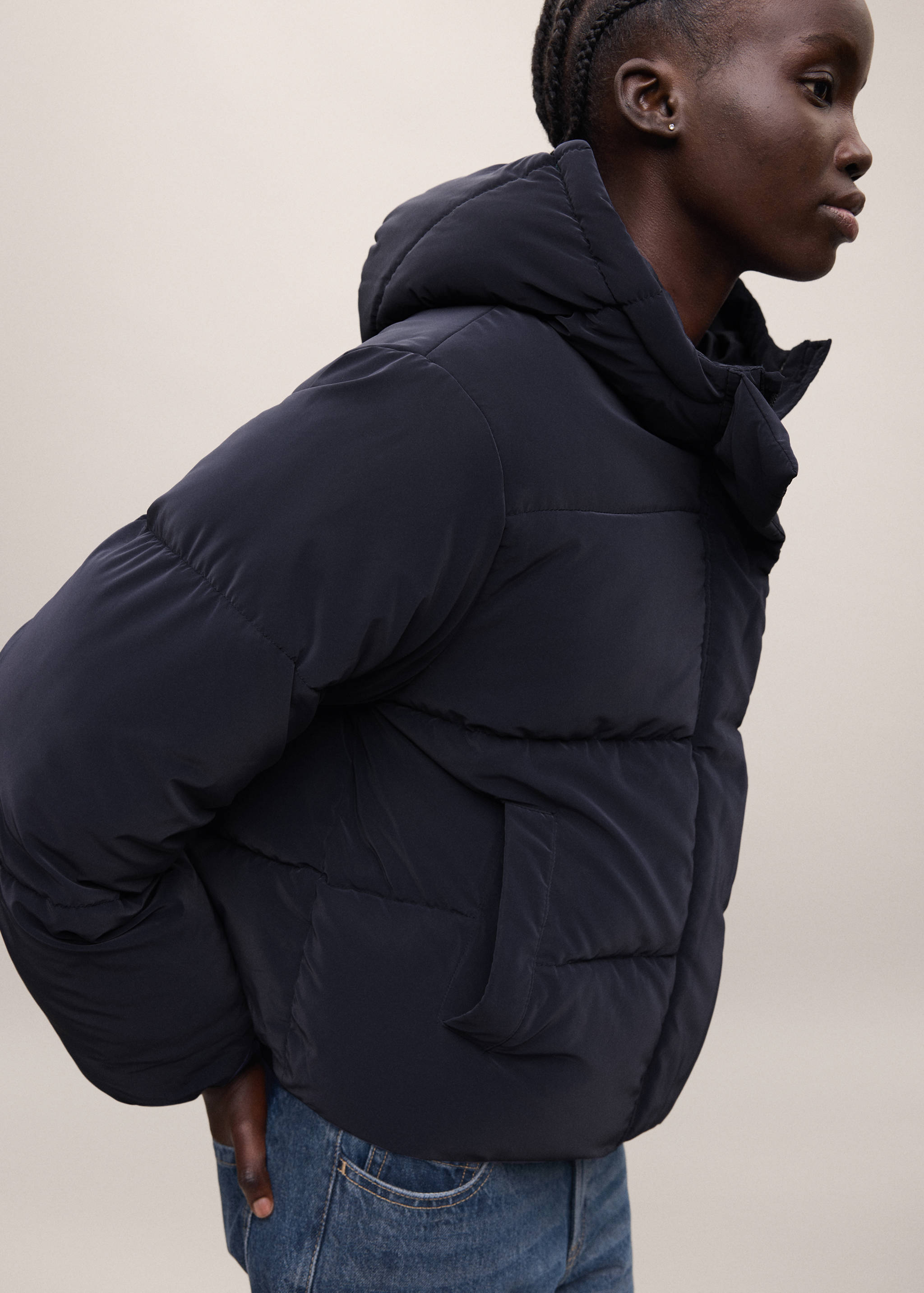 Navy blue quilted anorak with a hood and high collar.