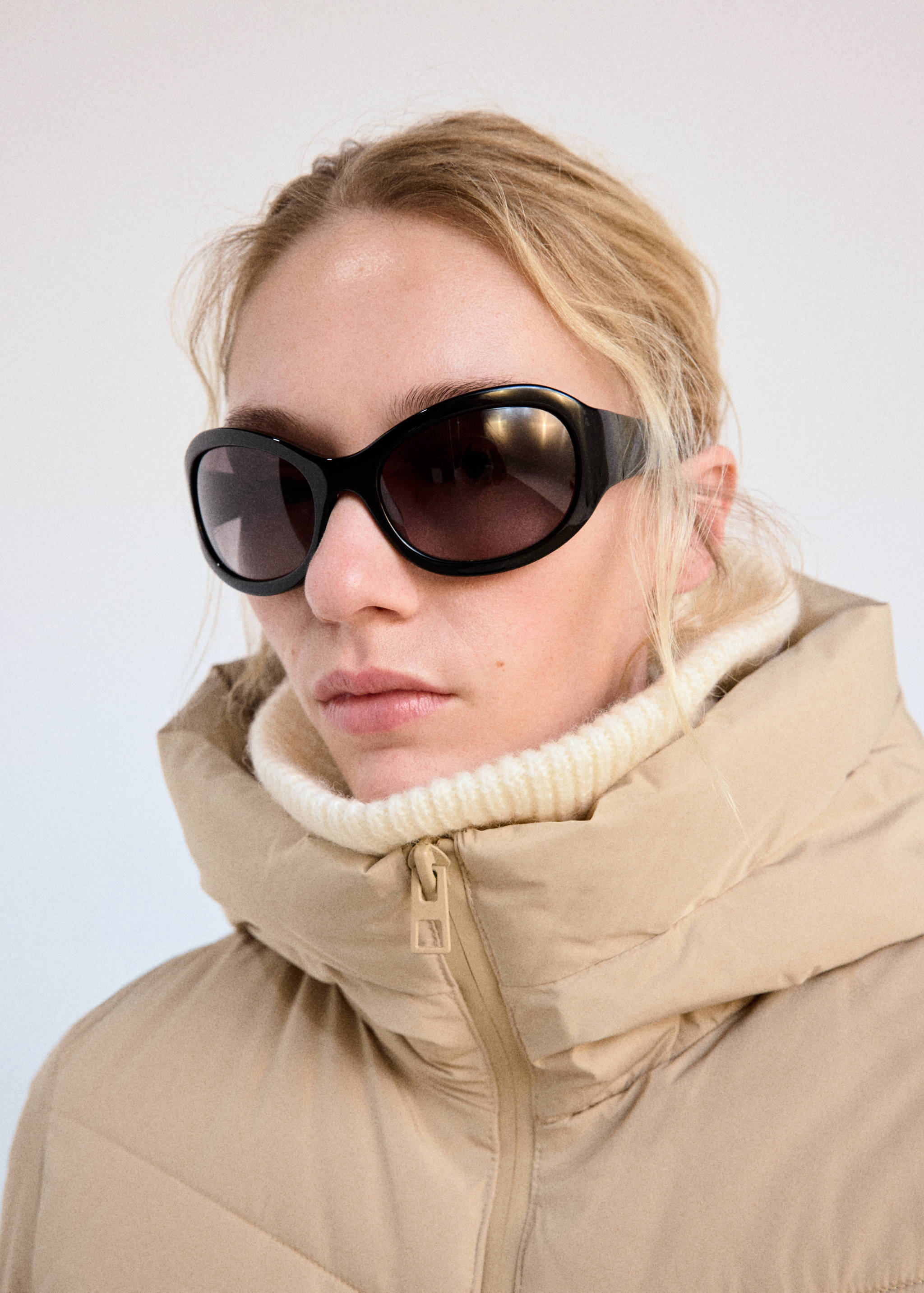 Beige anorak with a high collar and hood, shown in a close-up.