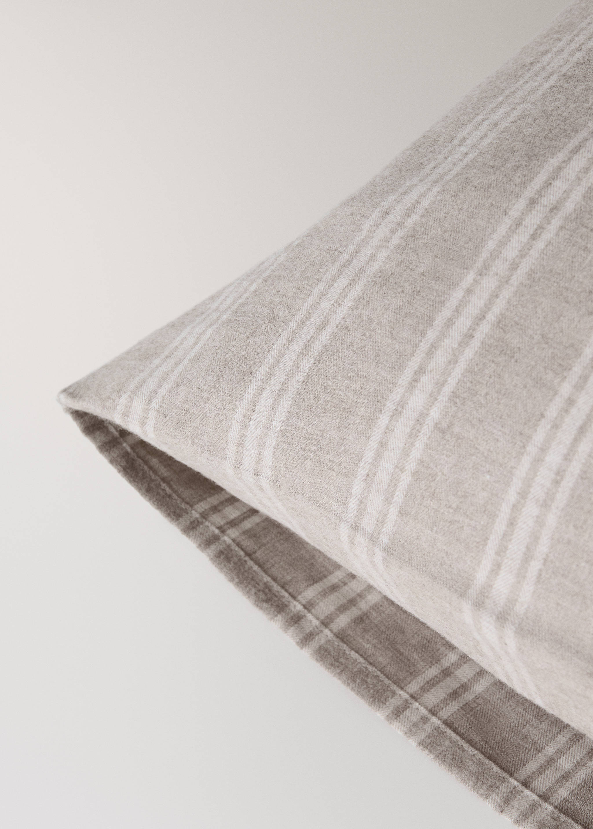 Close-up of a light beige and white striped pillowcase.