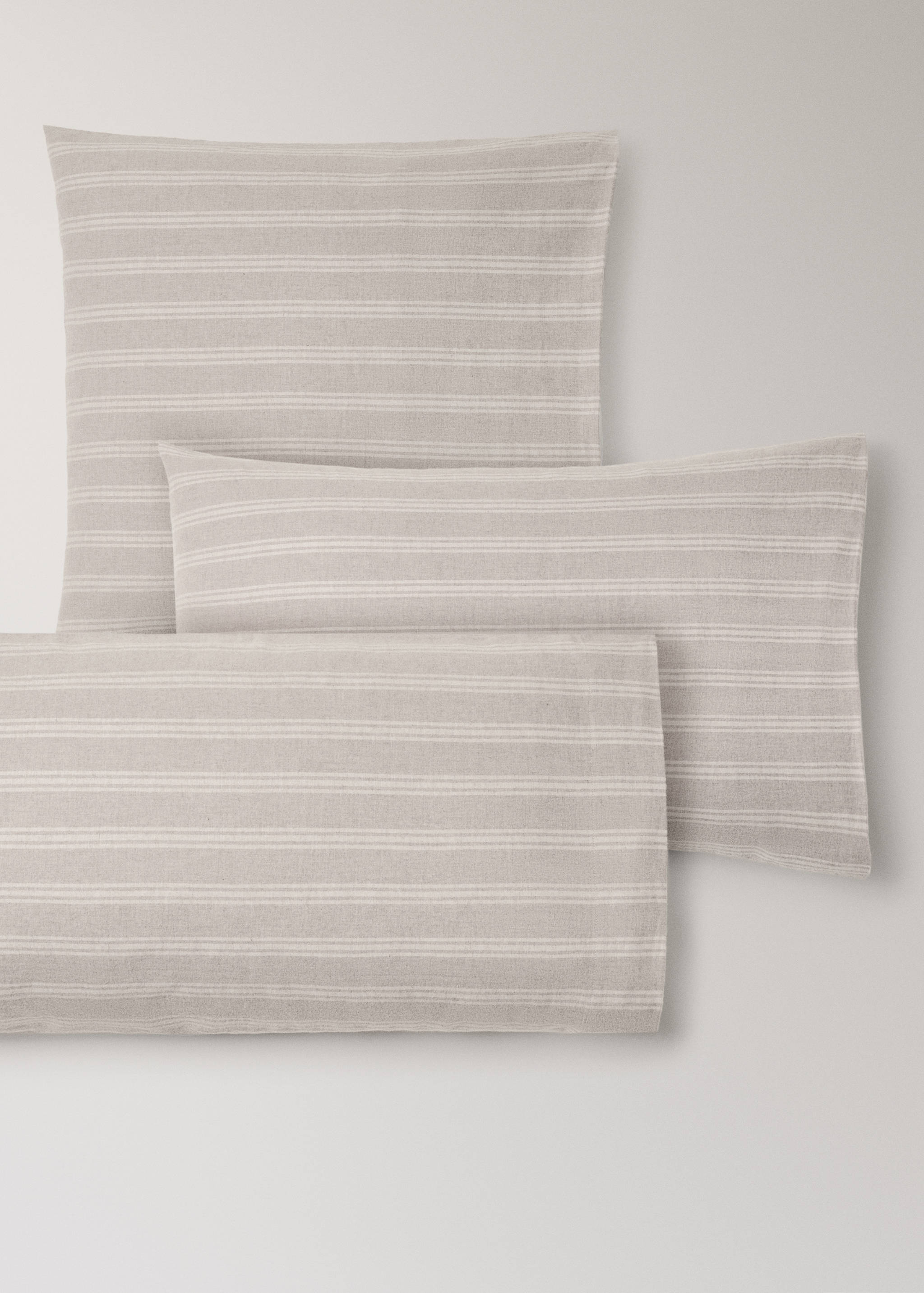 Beige and white striped pillowcases in textured fabric.