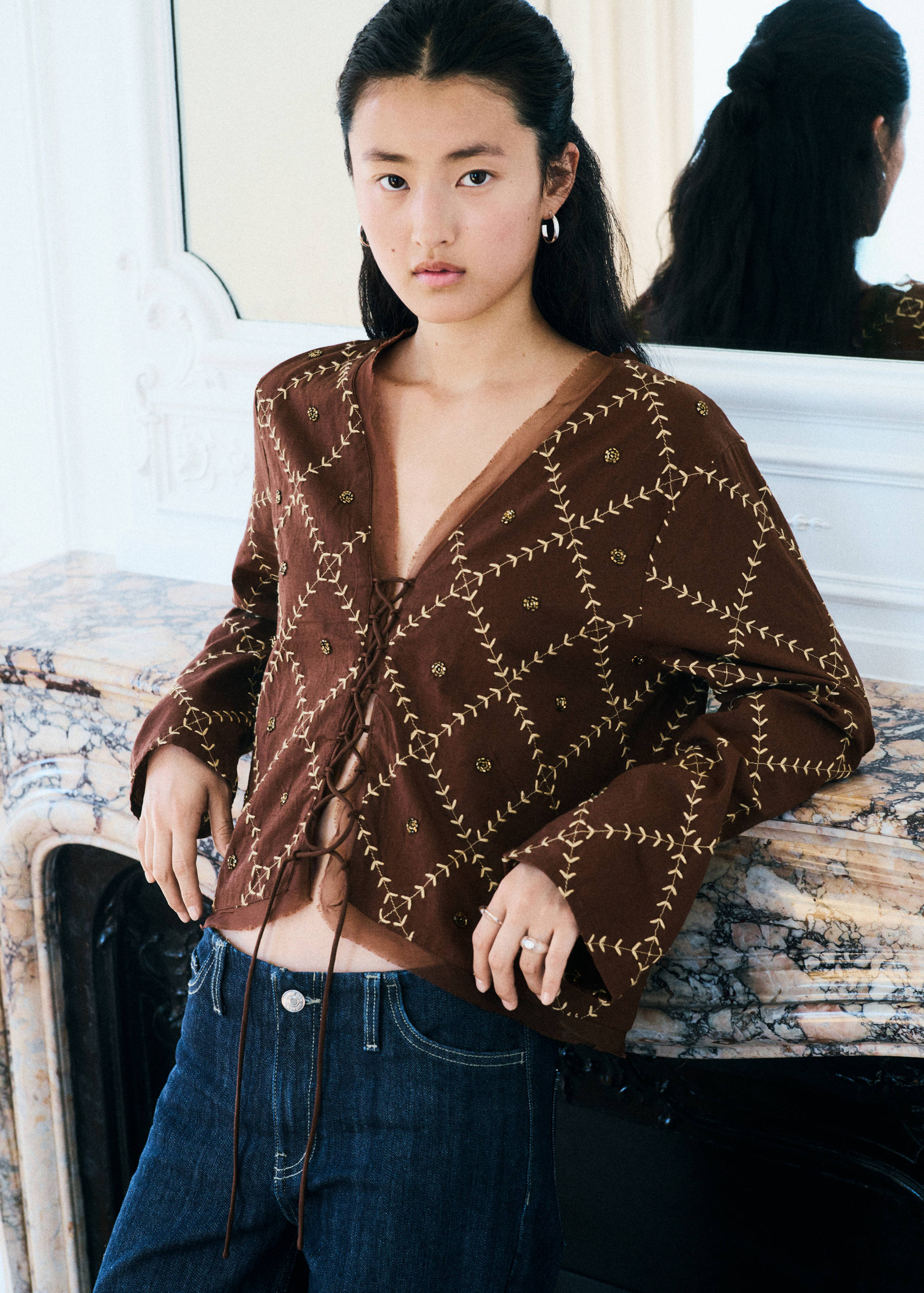 Brown long-sleeve top with yellow stitching and lace-up front.