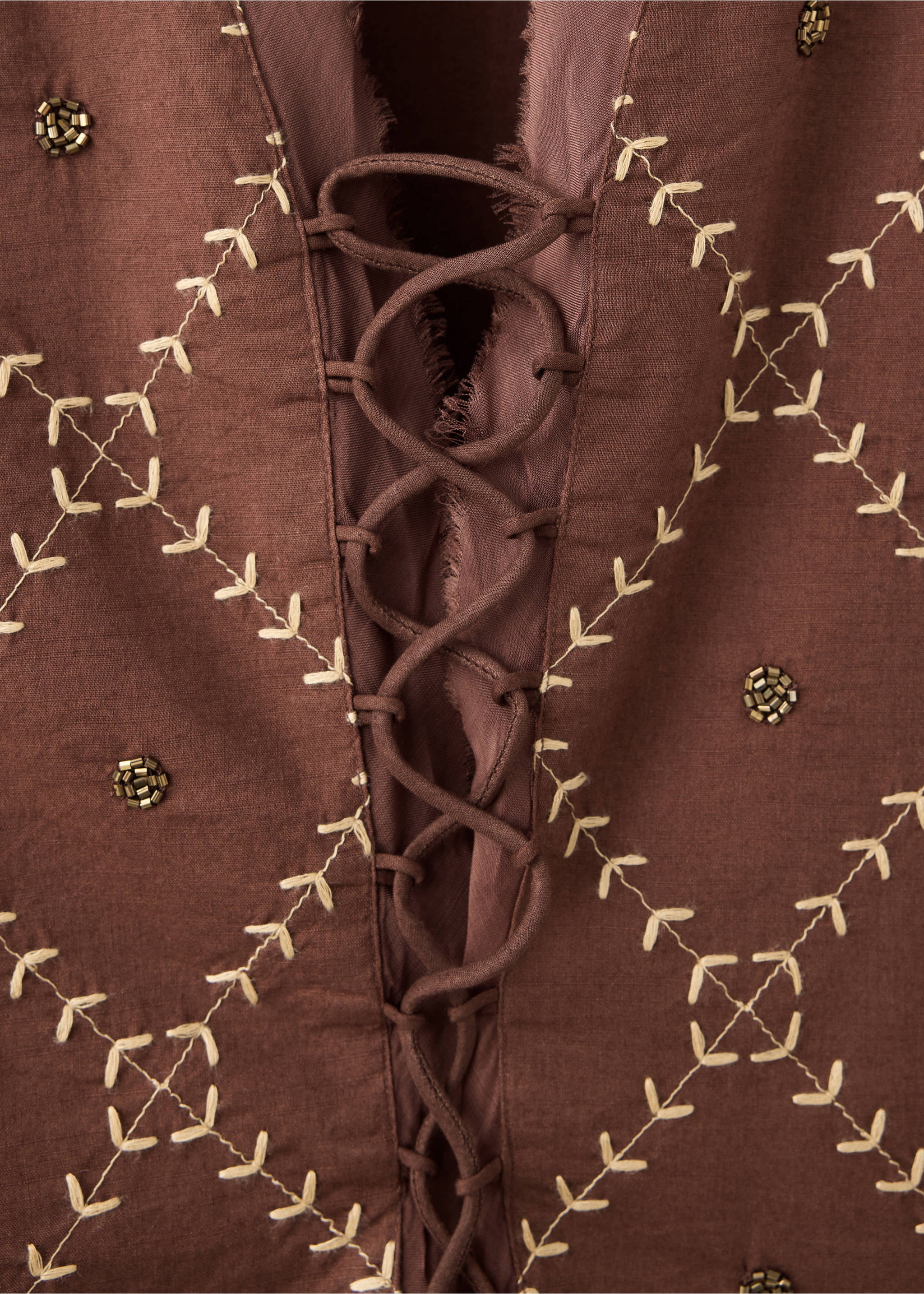 Close-up of a brown shirt with lace-up front, beige embroidery, and bead details., Caramel. Ref: 37018277-00.