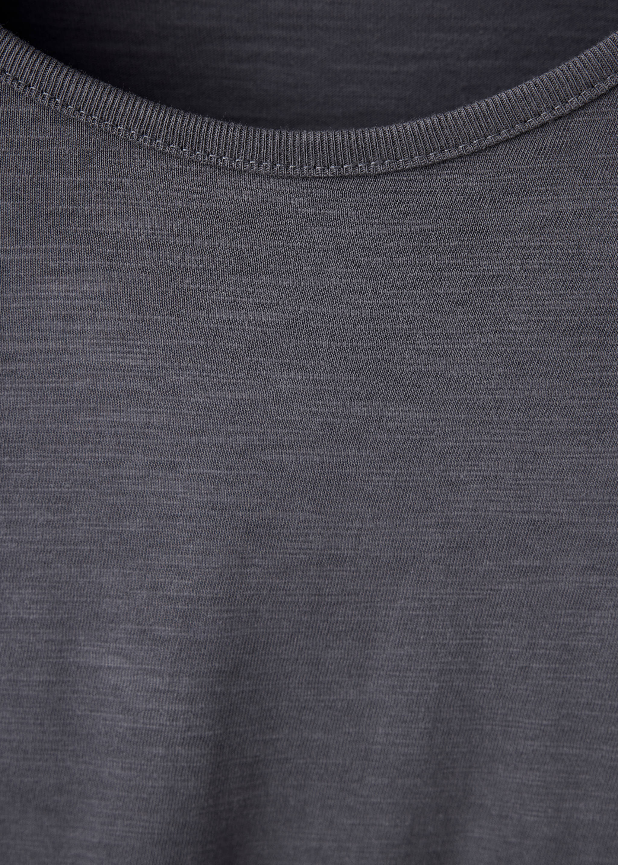 Primer plano de camiseta gris oscuro que muestra el cuello redondo de canalé.