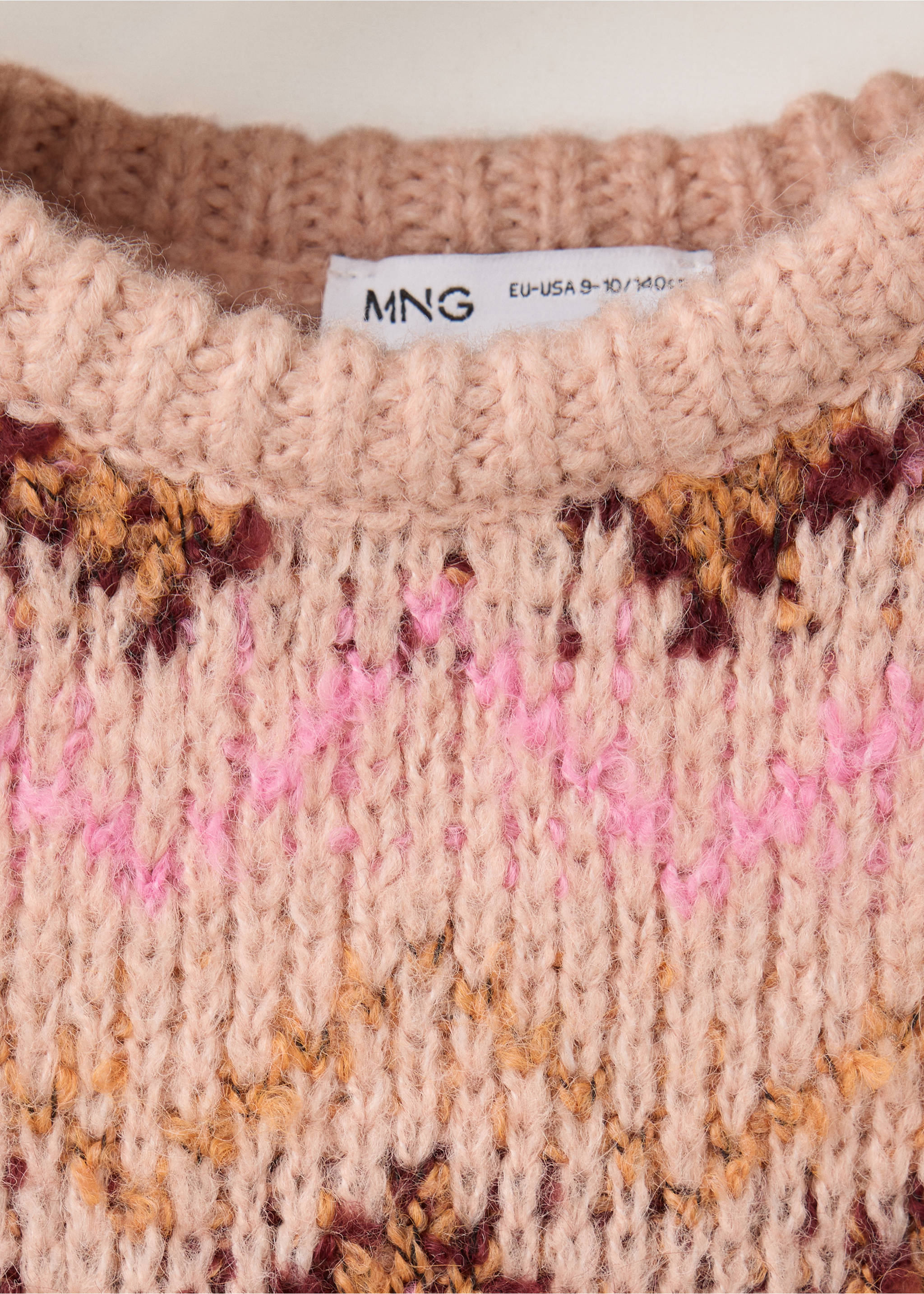 Primer plano de jersey de punto rosa con cuello redondo de canalé y estampado geométrico multicolor., Melocotón. Ref: 37018286-00.