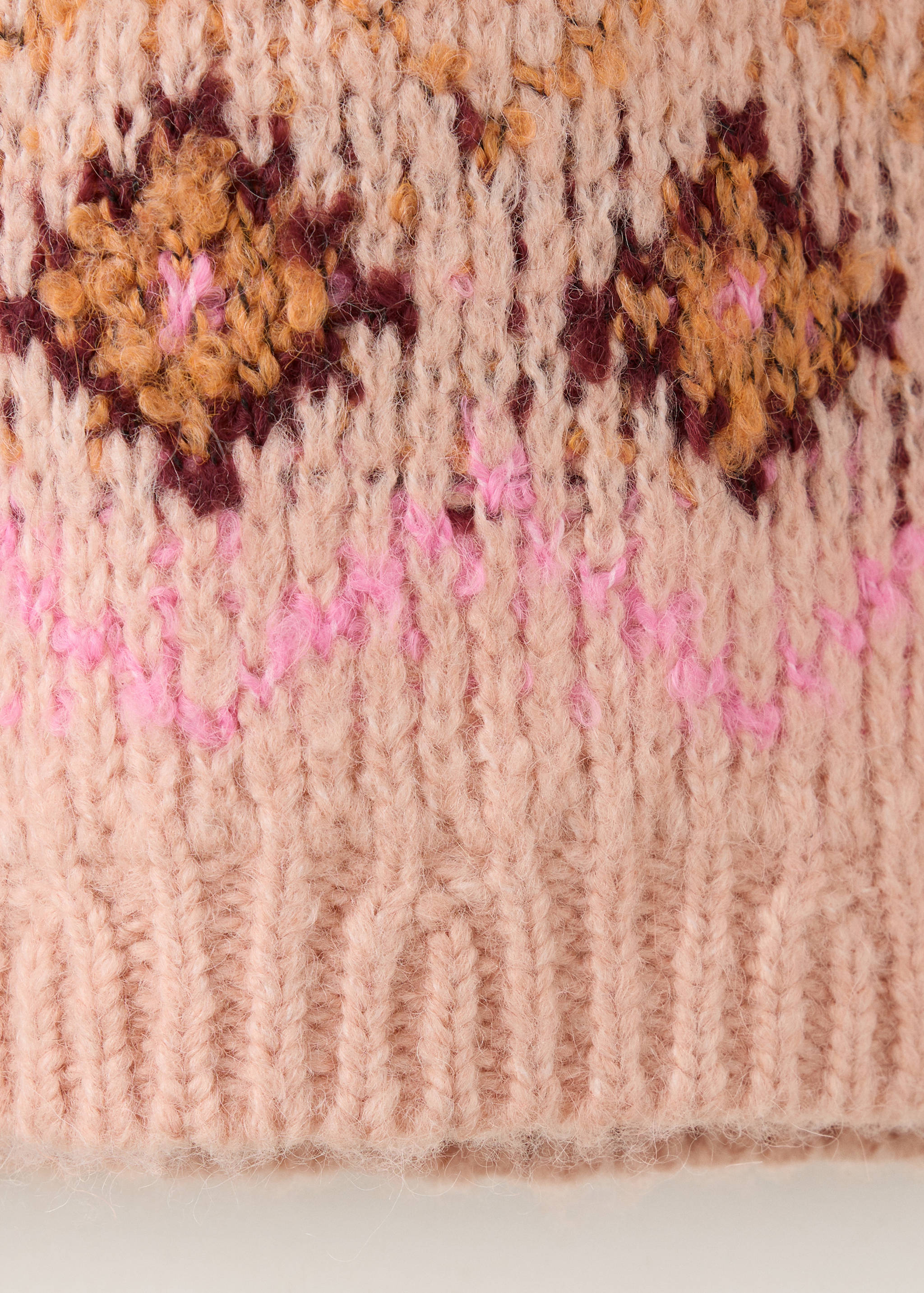 Primer plano del tejido de punto jersey afelpado en color rosa con una franja estampada.